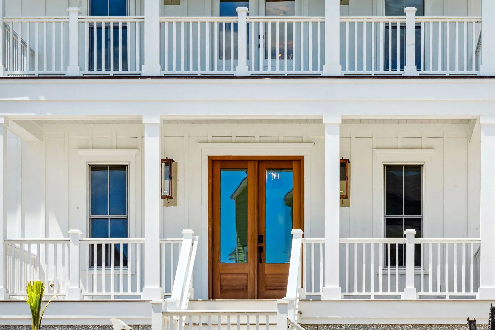 Mahogany front door and gas lanterns on elevated front porch in Daniel Island SC