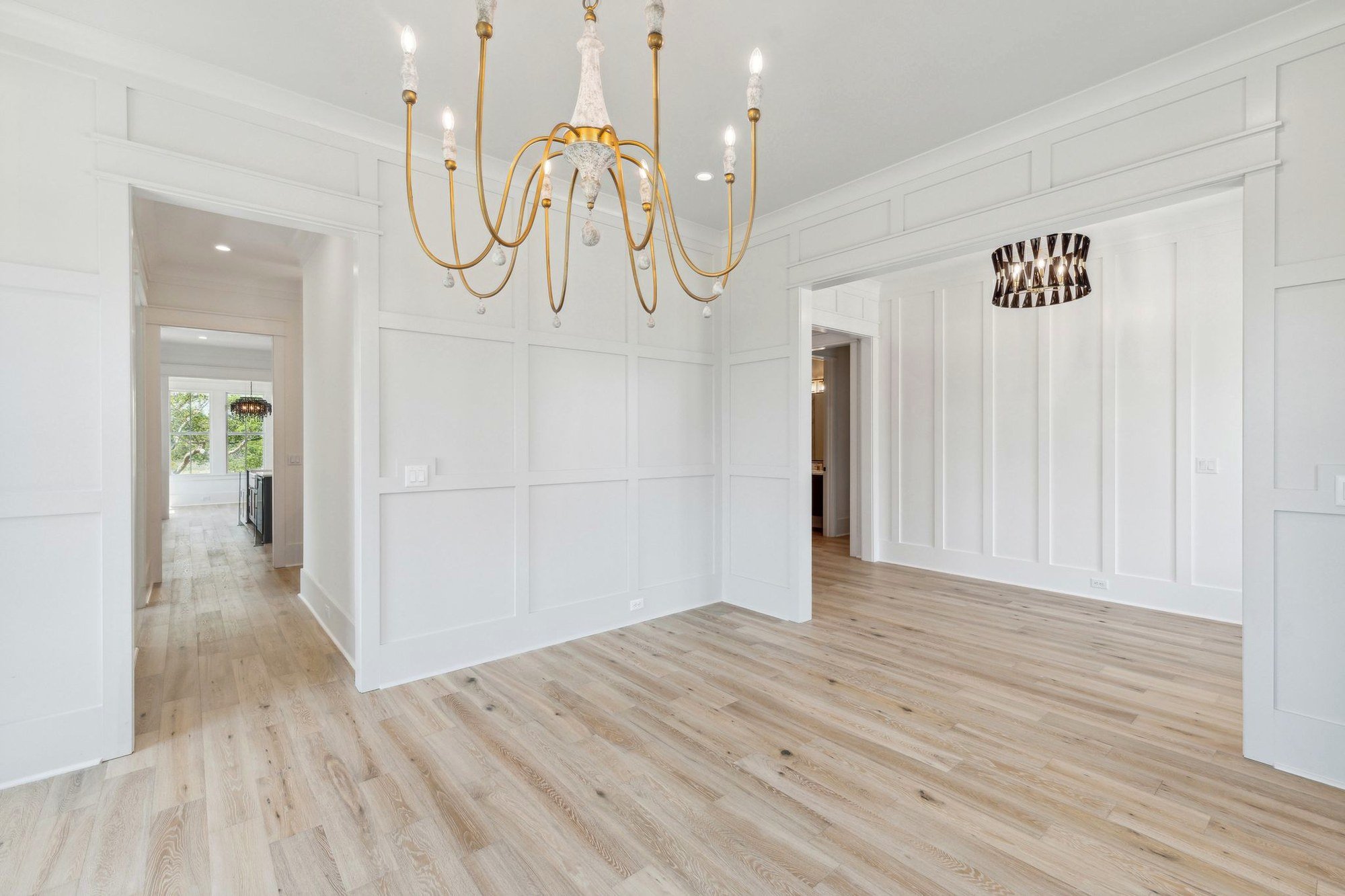 Dining room with brass chandelier and white oak floors in a Daniel Island SC custom home
