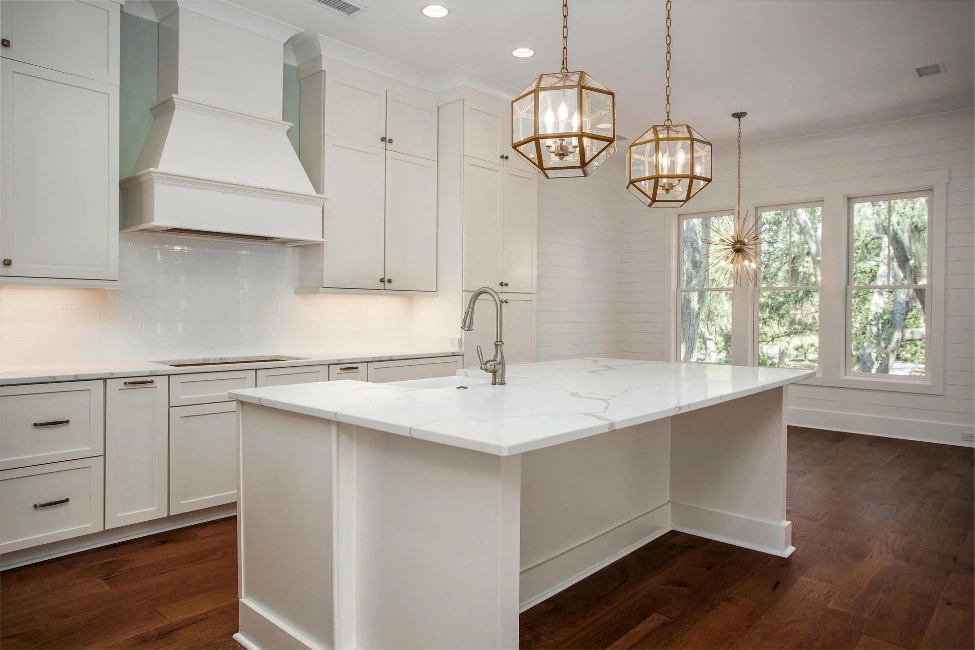 Kitchen island and custom range hood in a Charleston SC home by Iconic Developments