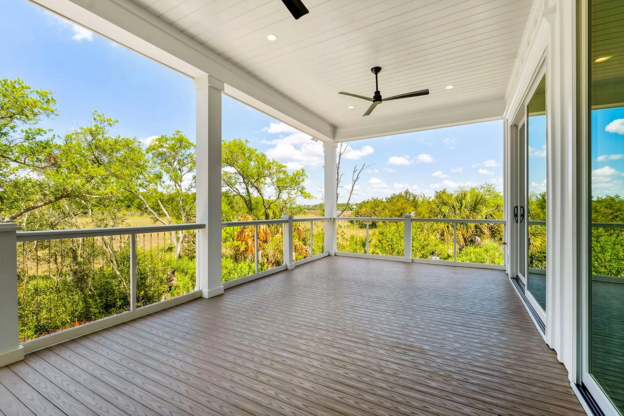 Covered rear porch overlooking Daniel Island SC marshland by Iconic Developments