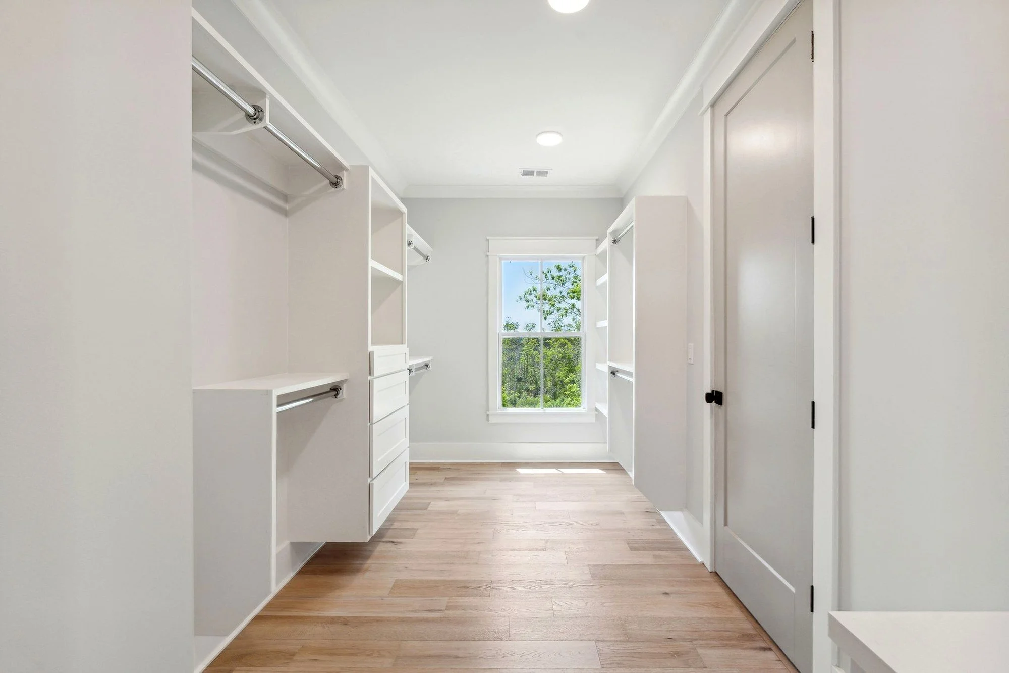 Walk-in closet hanging runs and custom cabinetry in a Charleston SC custom home build