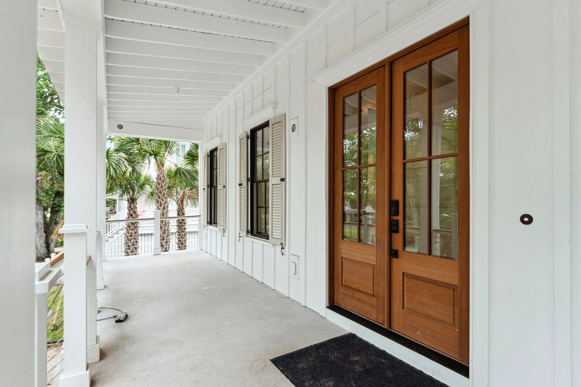 Deep front porch with mahogany double doors and a tongue-and-groove ceiling.