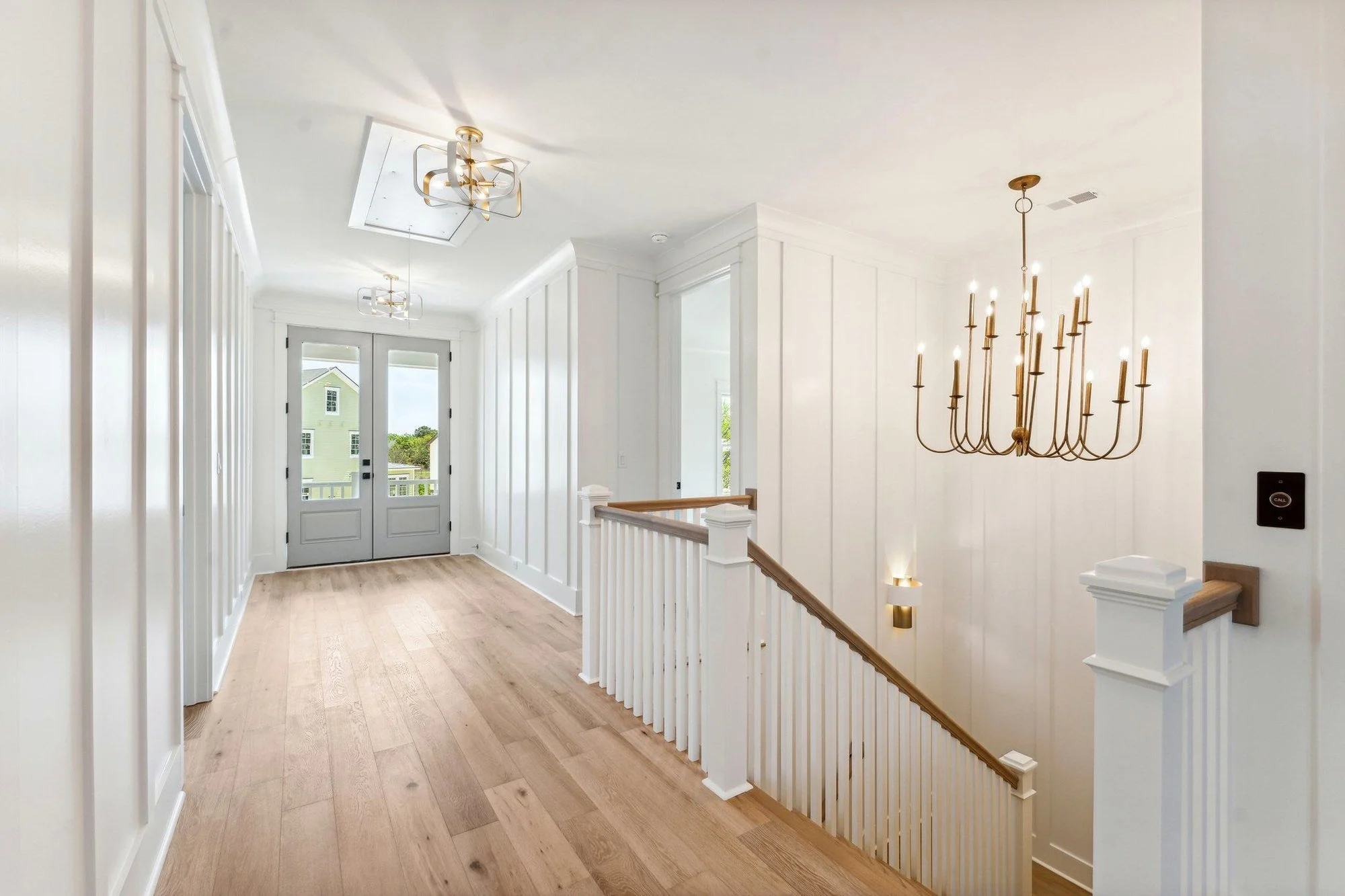 Paneled stair landing with brass chandelier in a Daniel Island SC luxury custom home