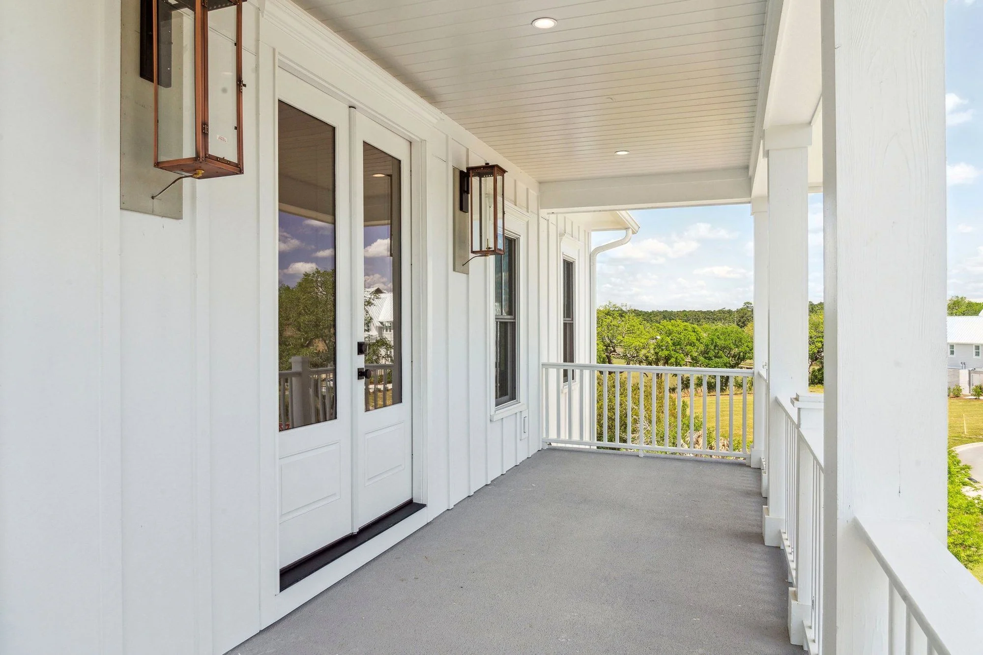 Upper level porch with gas lanterns facing the marsh in a Daniel Island SC custom home