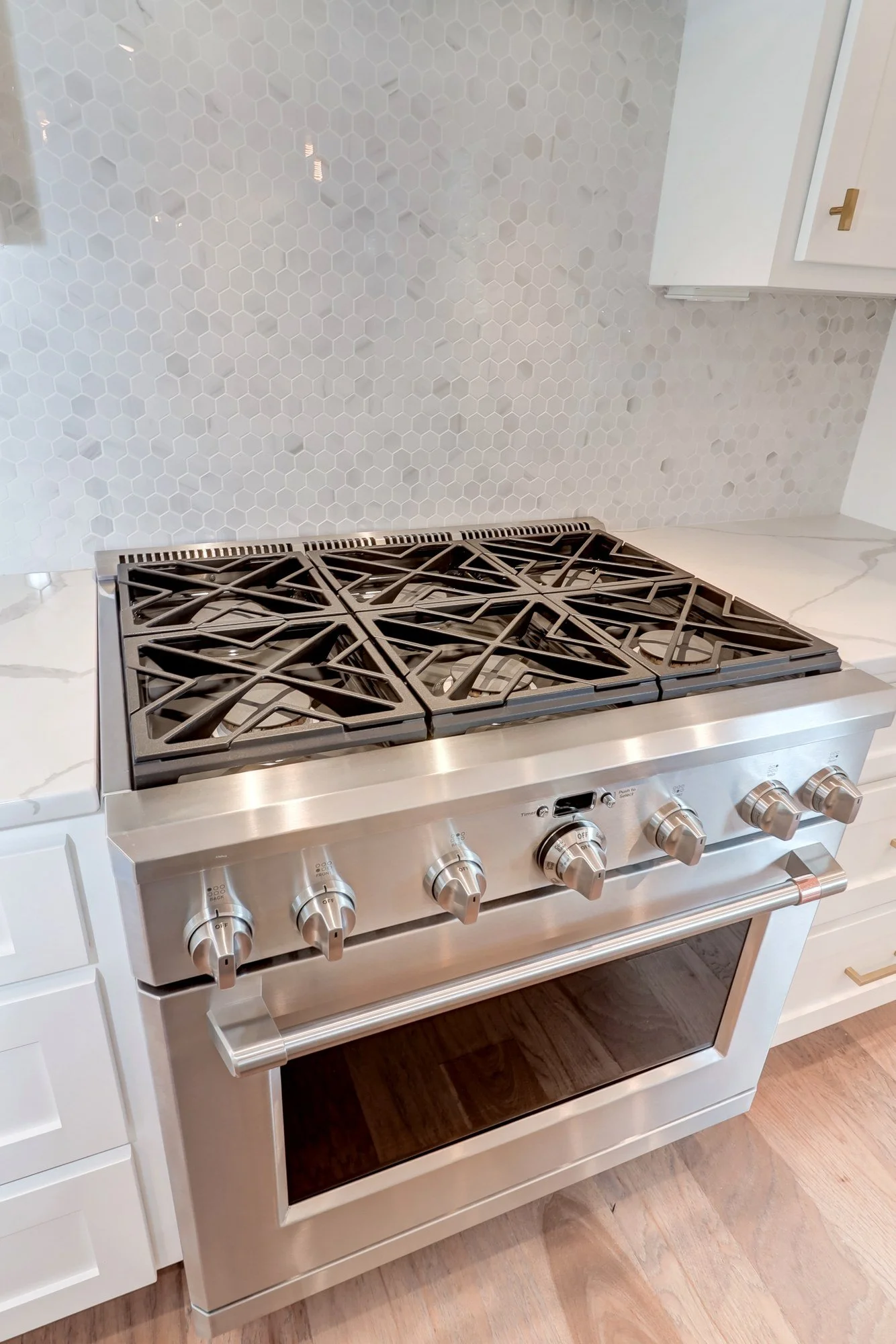 Gas range and marble mosaic backsplash in a Mount Pleasant SC custom kitchen build