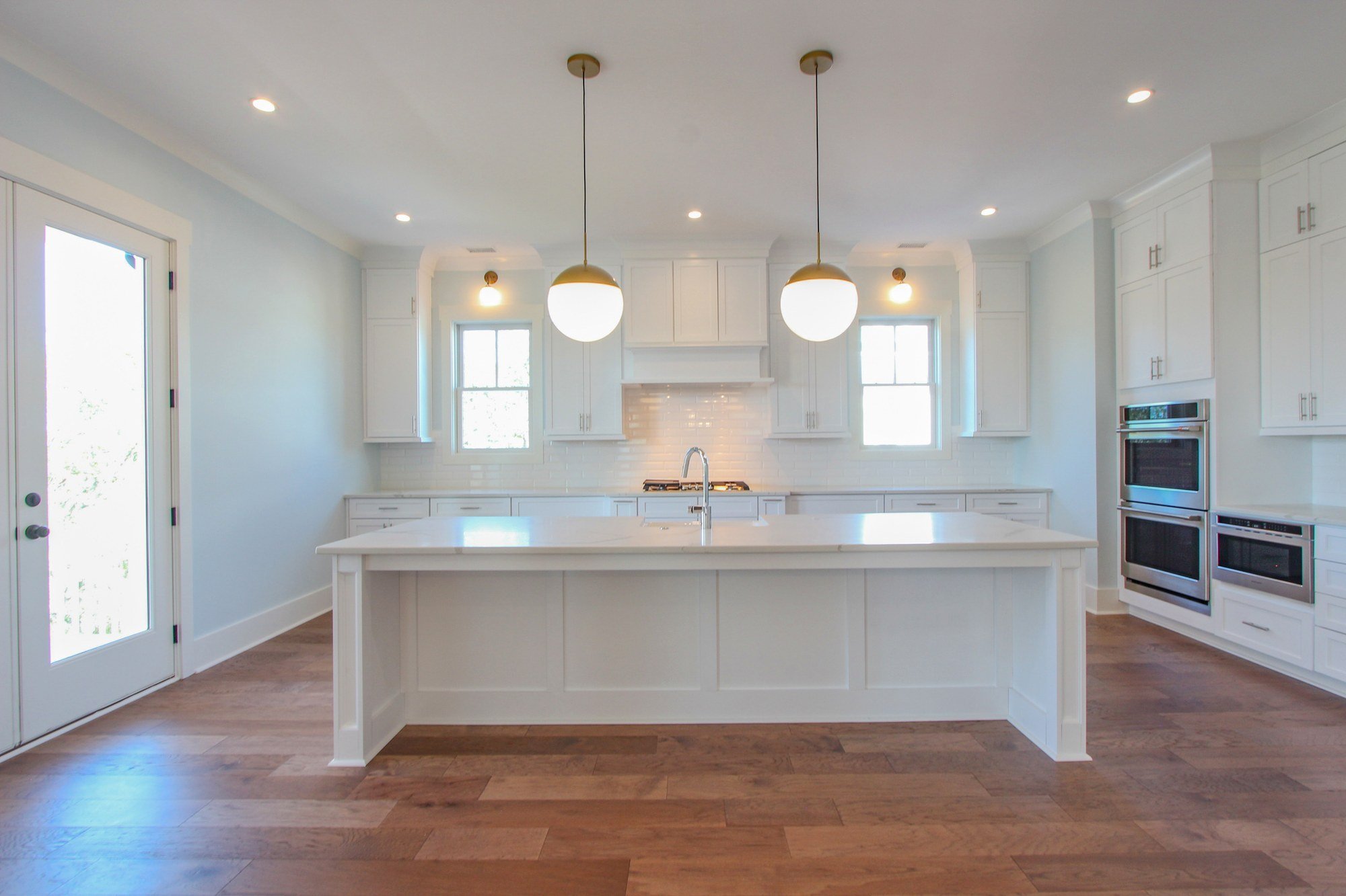 Custom kitchen island with glass pendant lighting in a Lowcountry coastal home