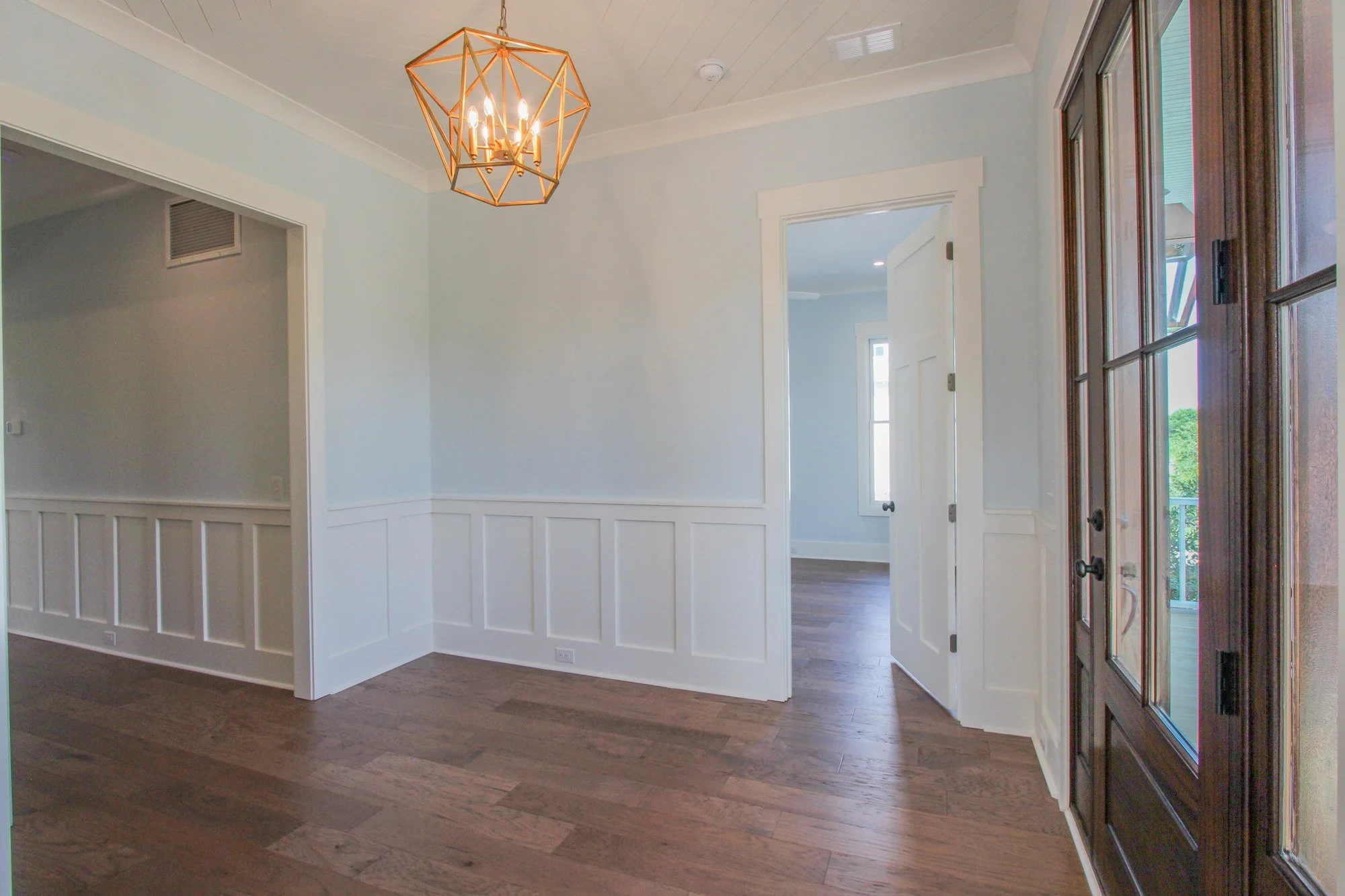 Dining room with brass lantern and heart pine floors in a Johns Island SC custom home
