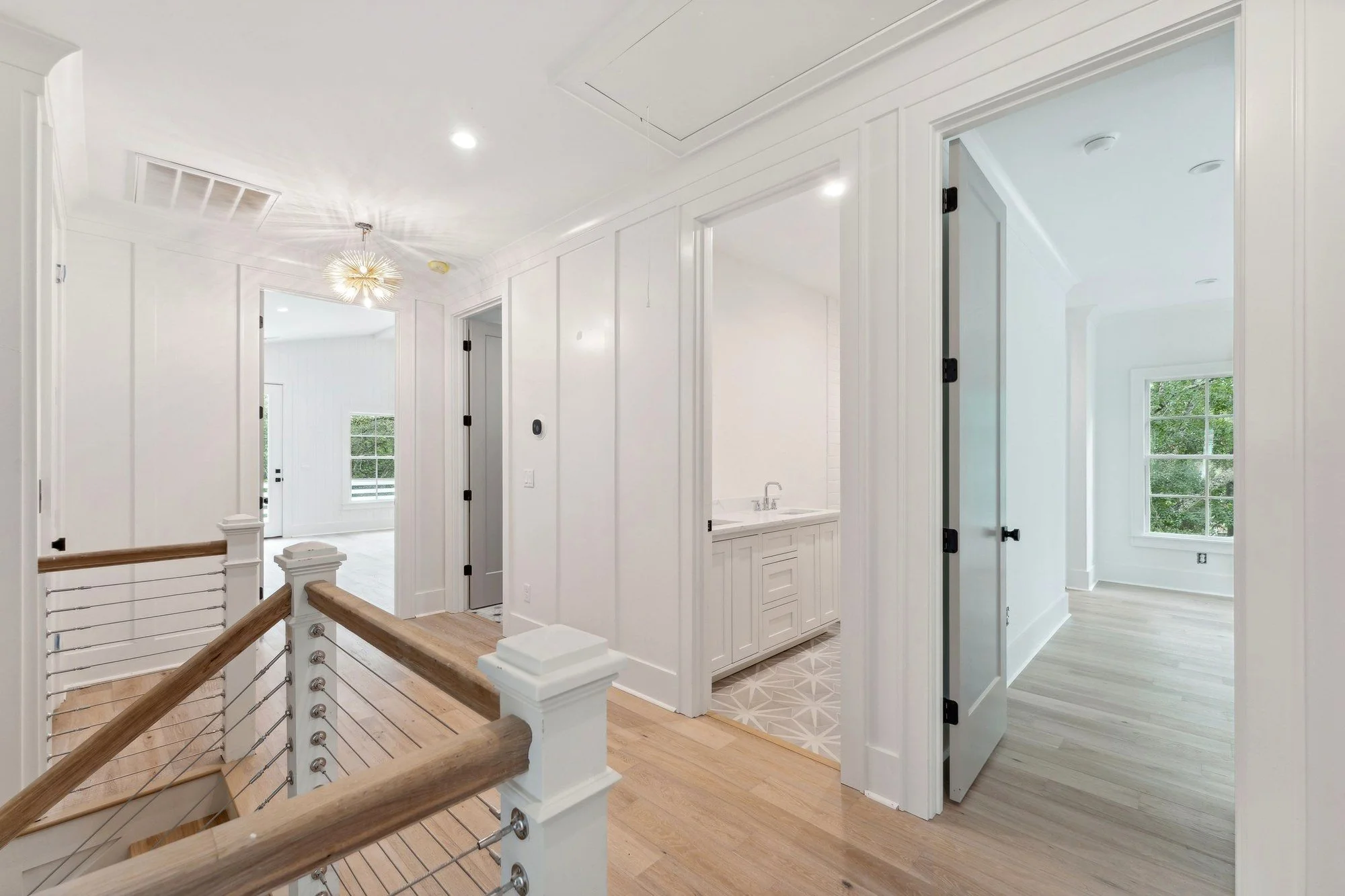 Upstairs landing with a chandelier over the open stair.