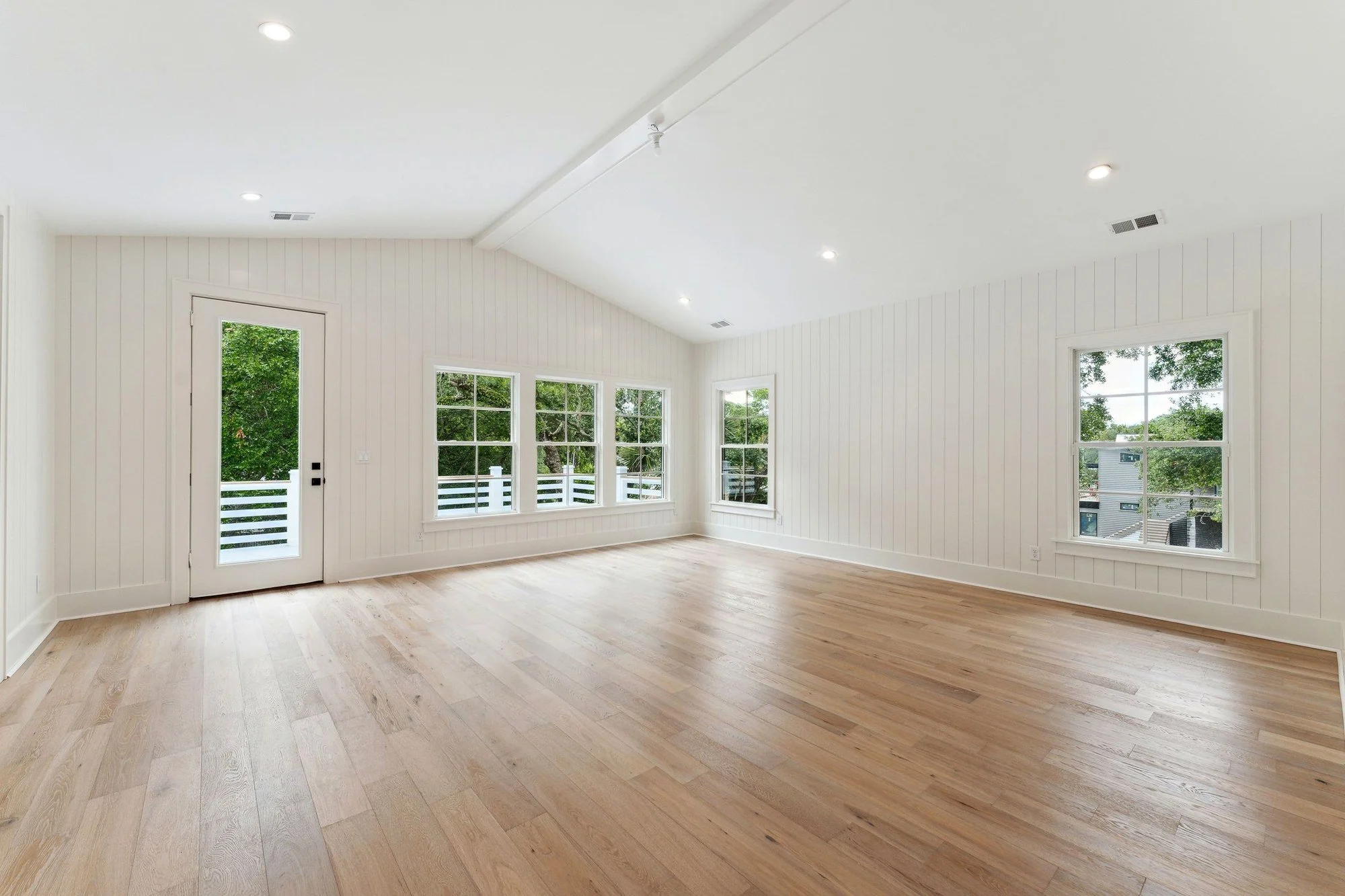 Bedroom with a vaulted shiplap ceiling and a French door to the porch.
