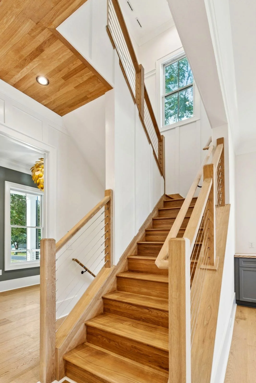 White oak staircase and wood plank ceiling in an Isle of Palms SC custom home build