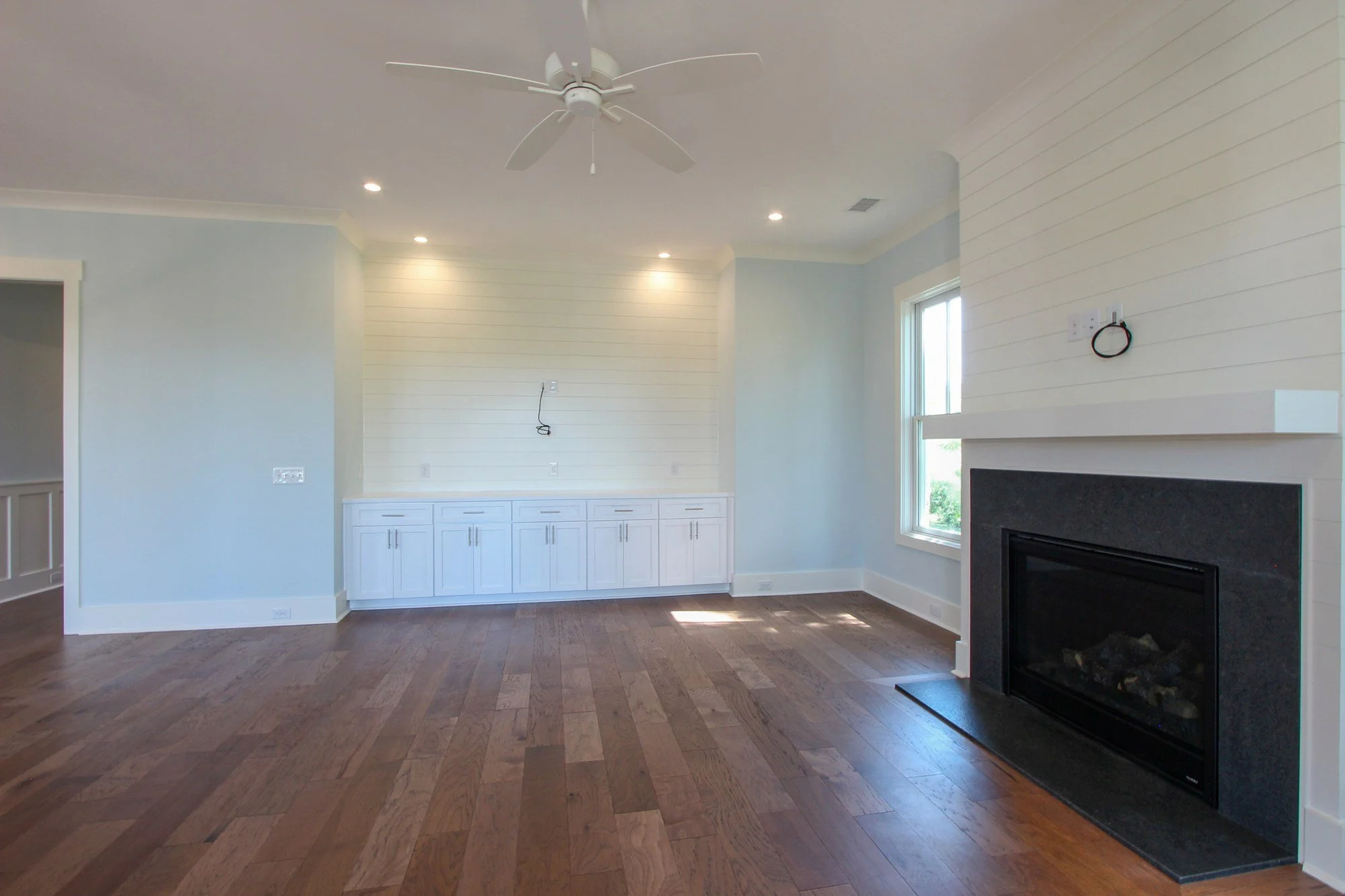 Living room featuring shiplap fireplace surround in a Charleston SC custom home