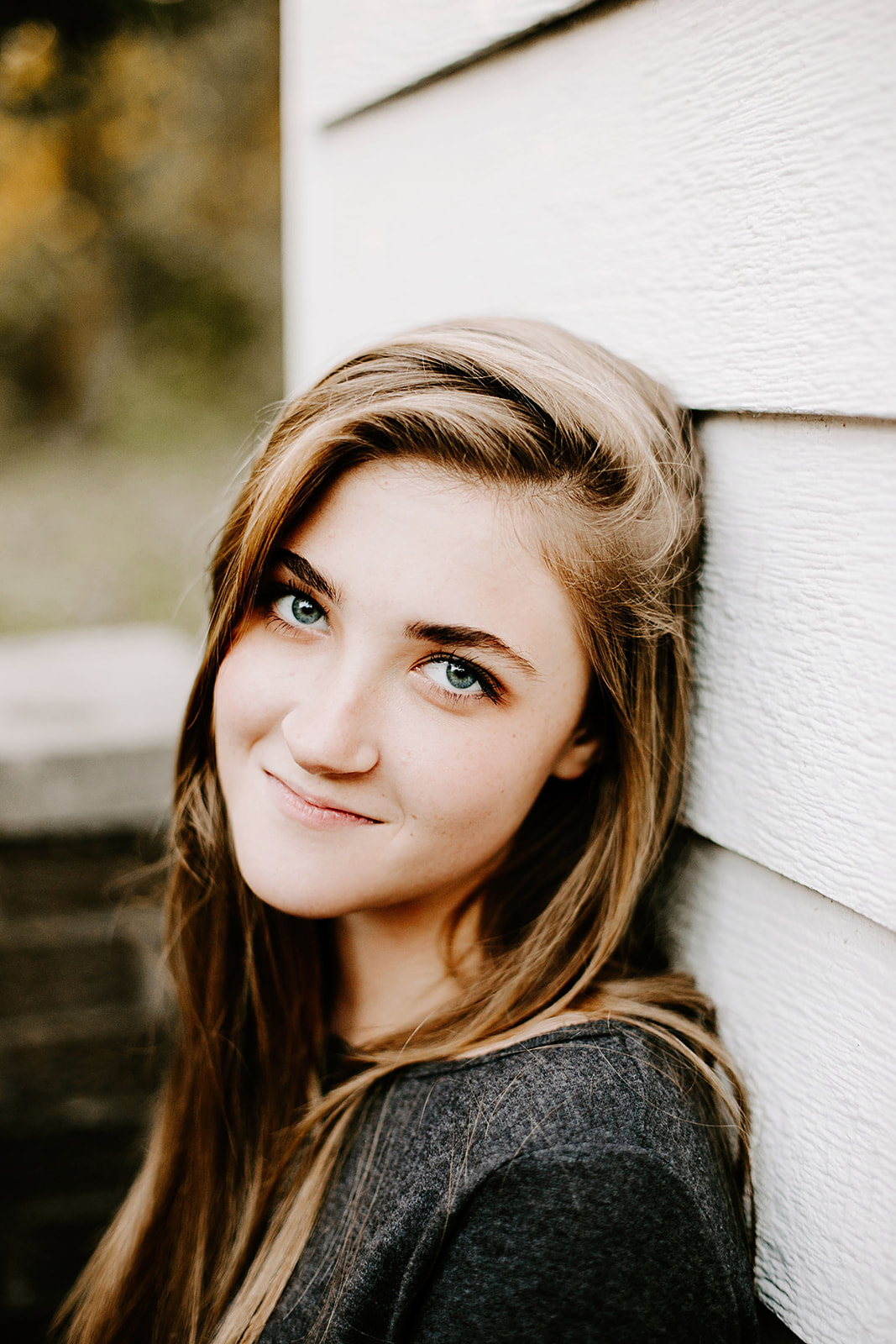 a senior photo at their senior session by a white wall at Carmel, Indiana