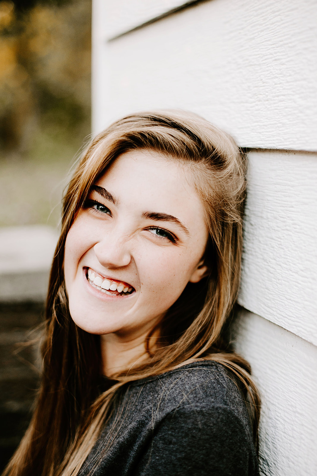 a senior photo at their senior session by a white wall at Carmel, Indiana