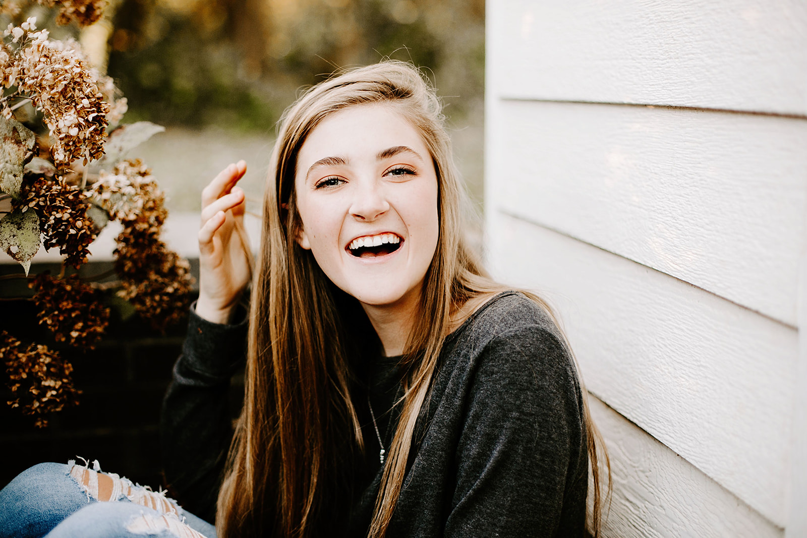 a senior photo at their senior session by a white wall at Carmel, Indiana