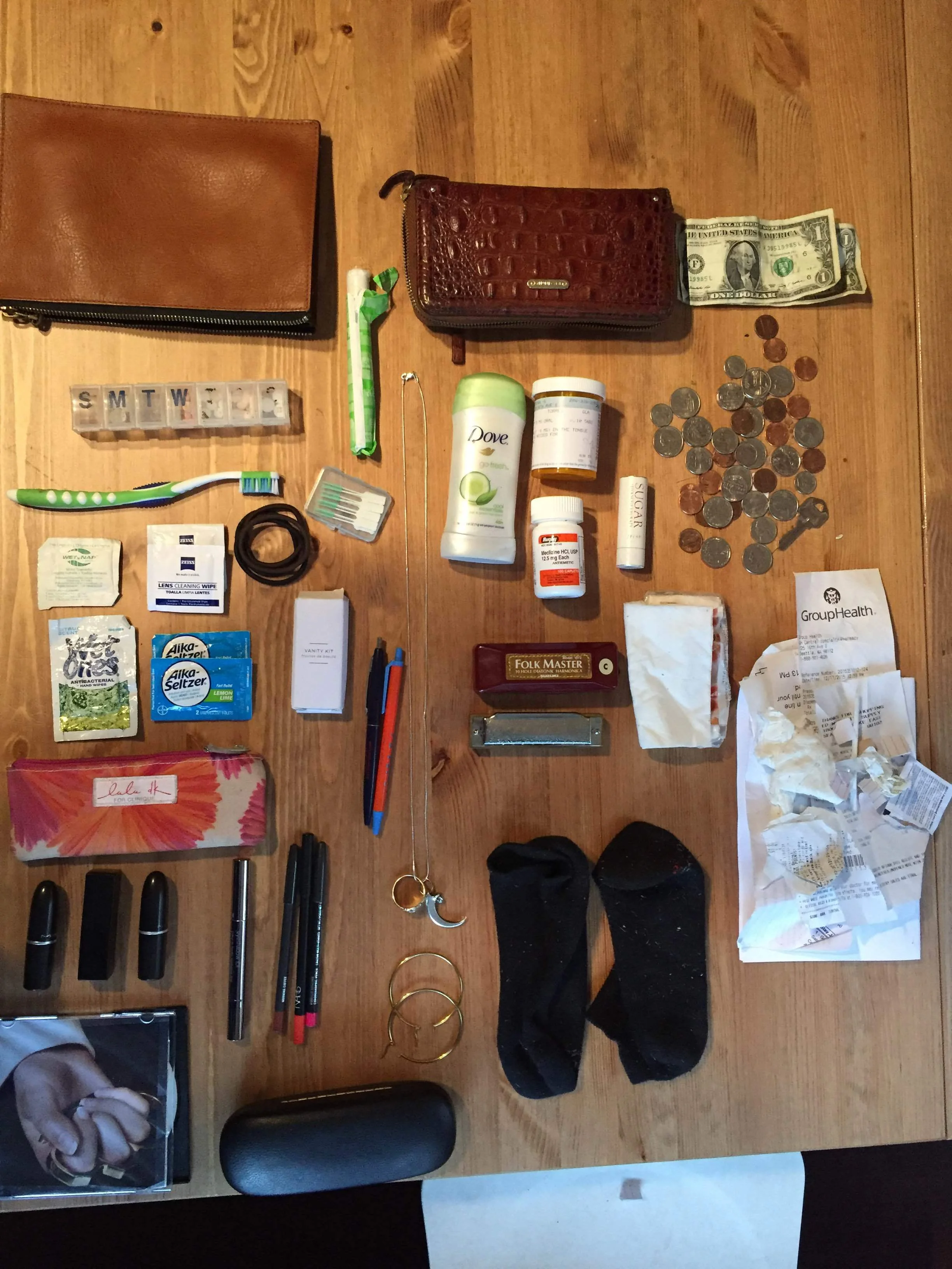  -Small brown leather bag or satellite bag one.&nbsp; Pill organizer with various vitamins, aspirin, naproxen, Mexican Valium and antidepressants.&nbsp; Tampon Flossing toothpicks Ponytail holders Toothbrush Lens cleaning wipes Wet nap Alka seltzer S