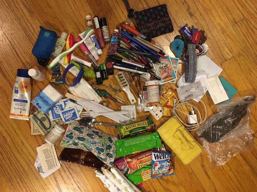  Pictured: 17 pens 2 highlighters Pouch of business cards and 67 cents in change $30 cash 2 pairs of sunglasses (one in cactus sunglass case) 2 Garbage Pail Kids cards 5 flash drives Travel-sized hairbrush Airport parking receipt Bag of spicy beef je