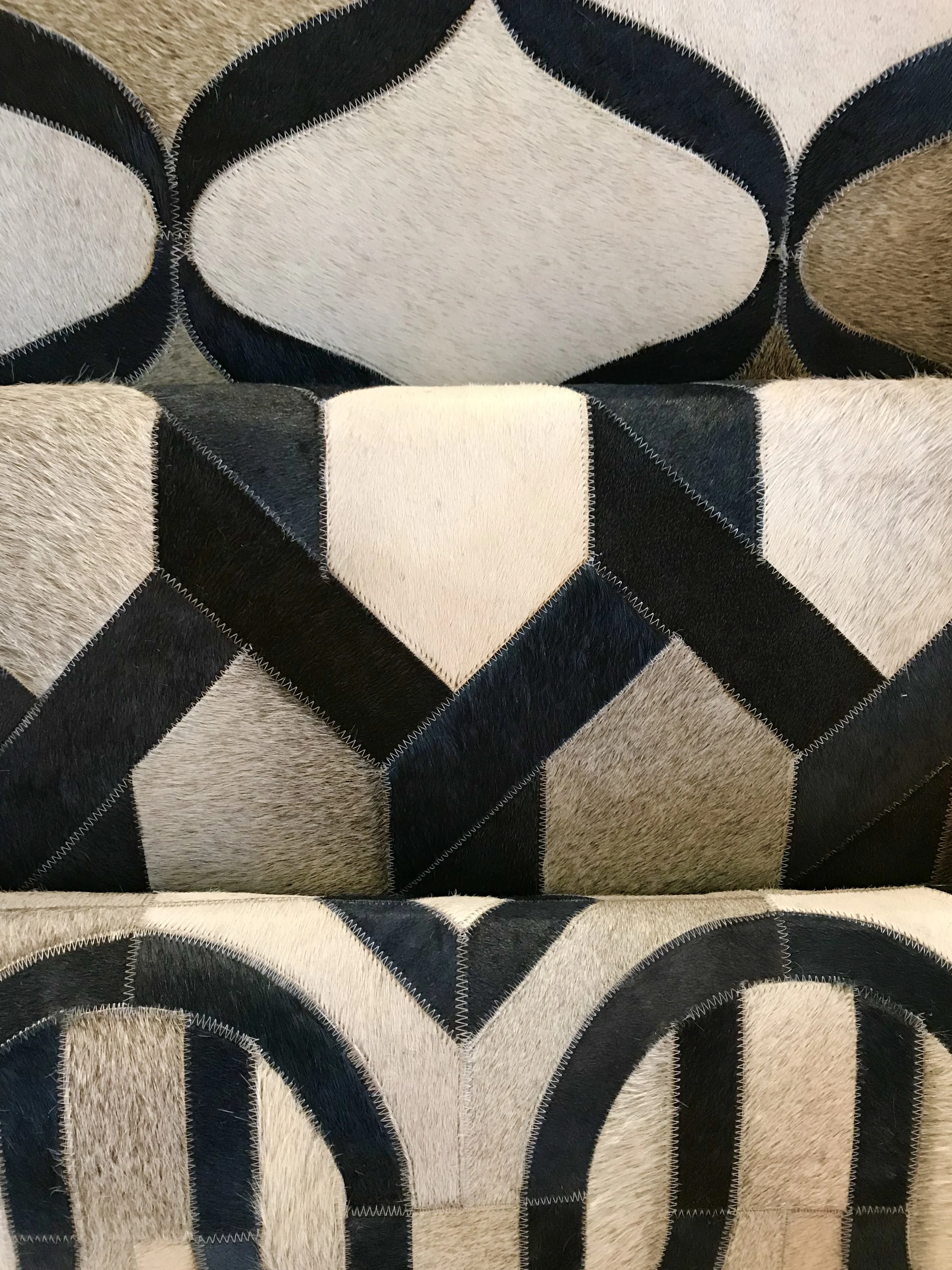 How fantastic are these natural colored hide rugs with navy dyed pieces patched in featuring updated designs!