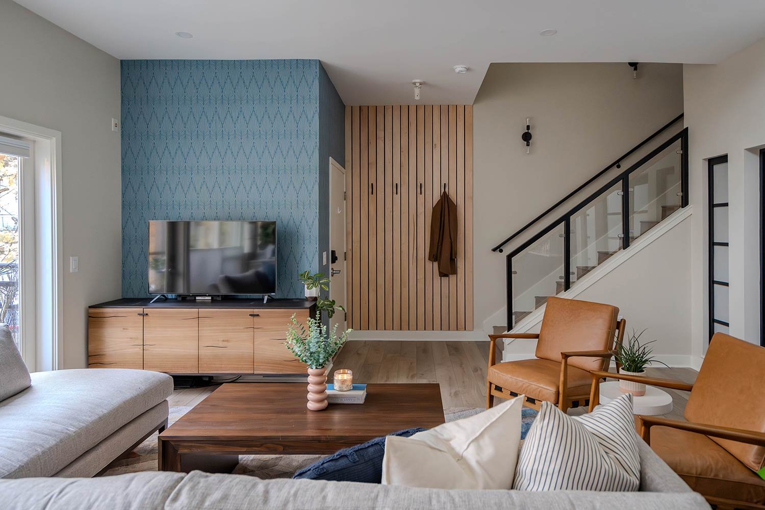 Wood panneled entry way with unique wallpaper wrapping wall