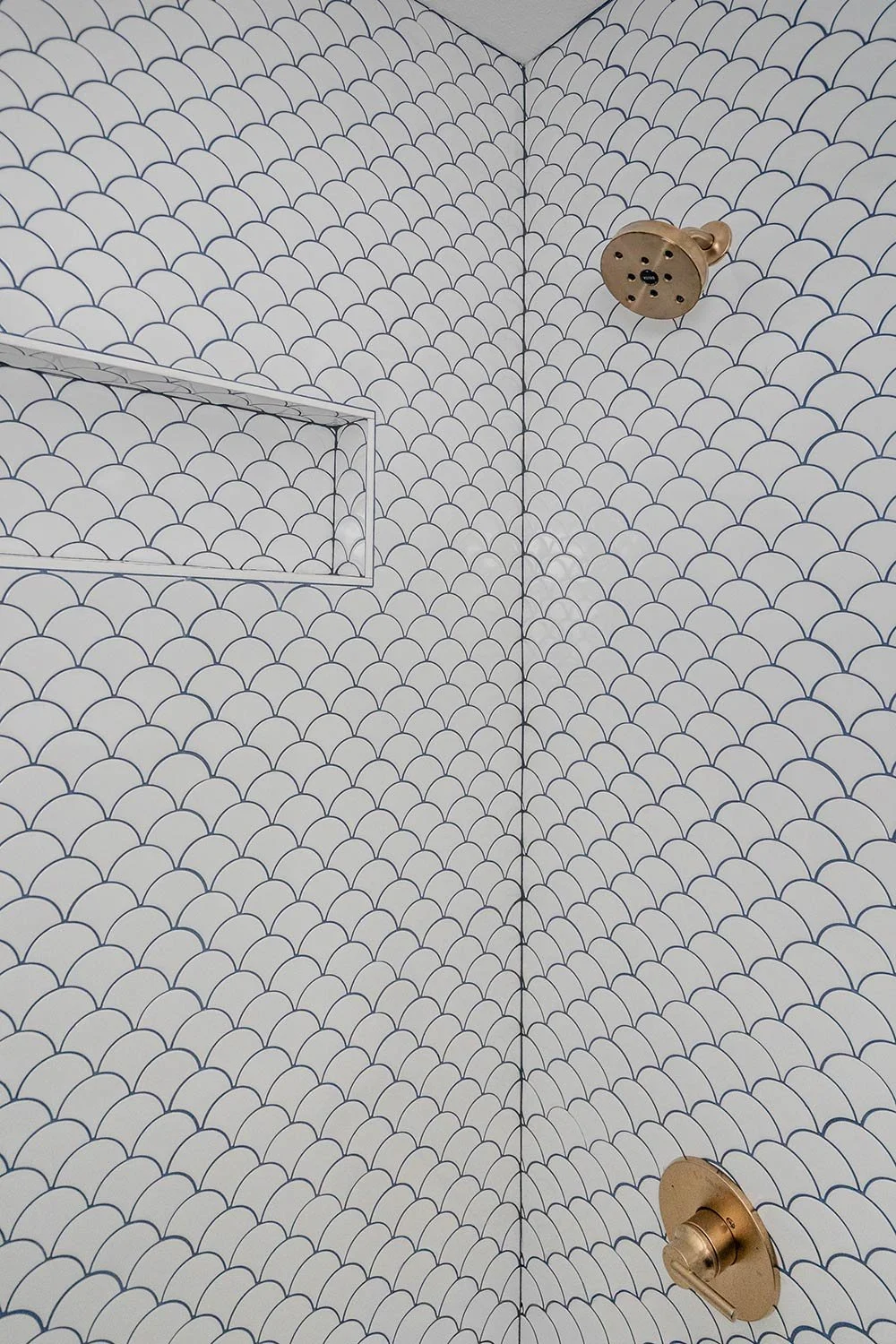 blue grout with rounded white tile and gold hardware