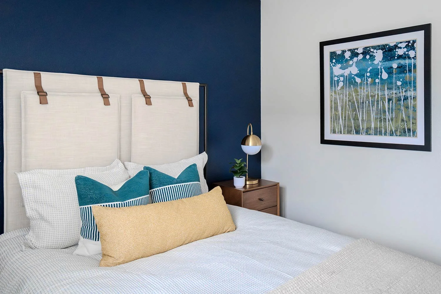 Tall upholstered headboard with mid-century modern lamps