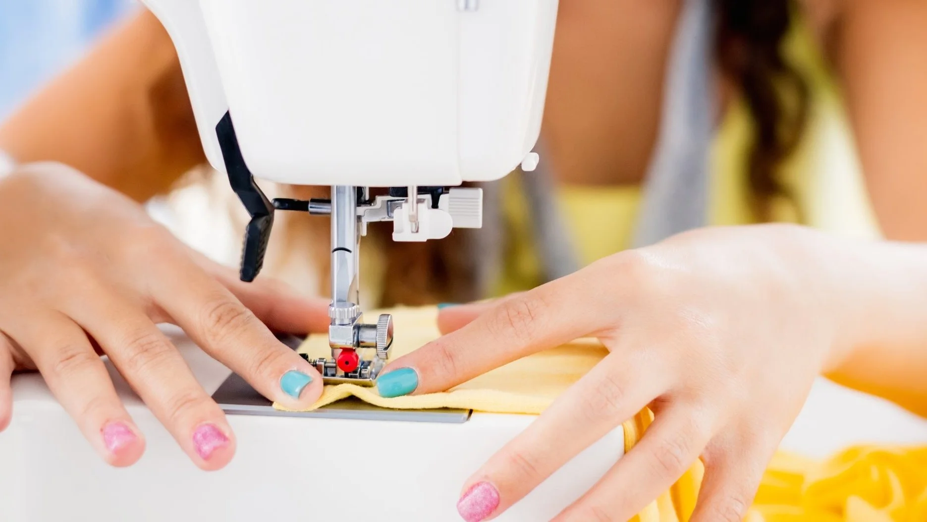 Student sewing on the sewing machine in fashion design class