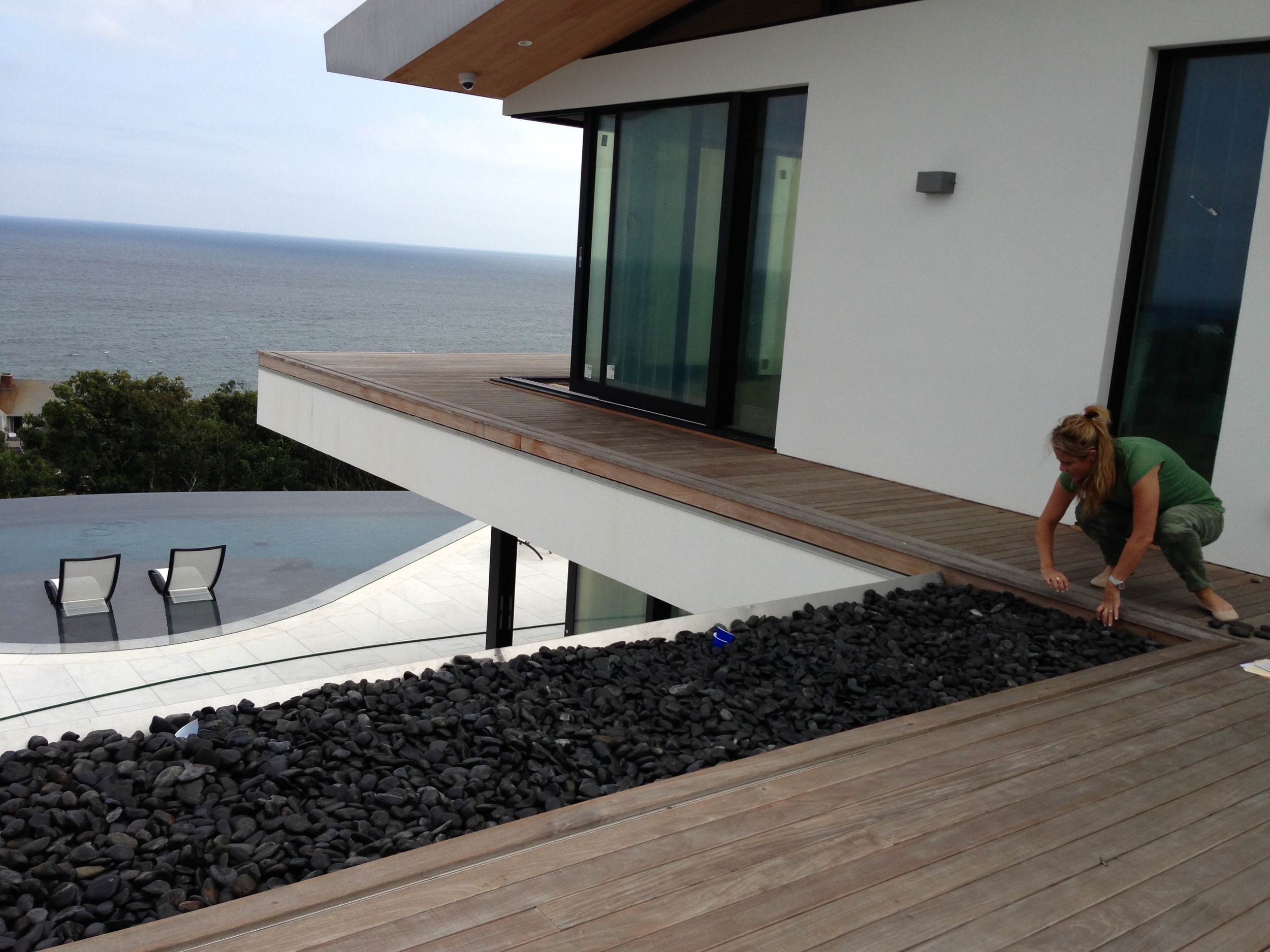 Steph selecting a river rock from the Roof Deck to be used as a model for the Living Room coffee table.