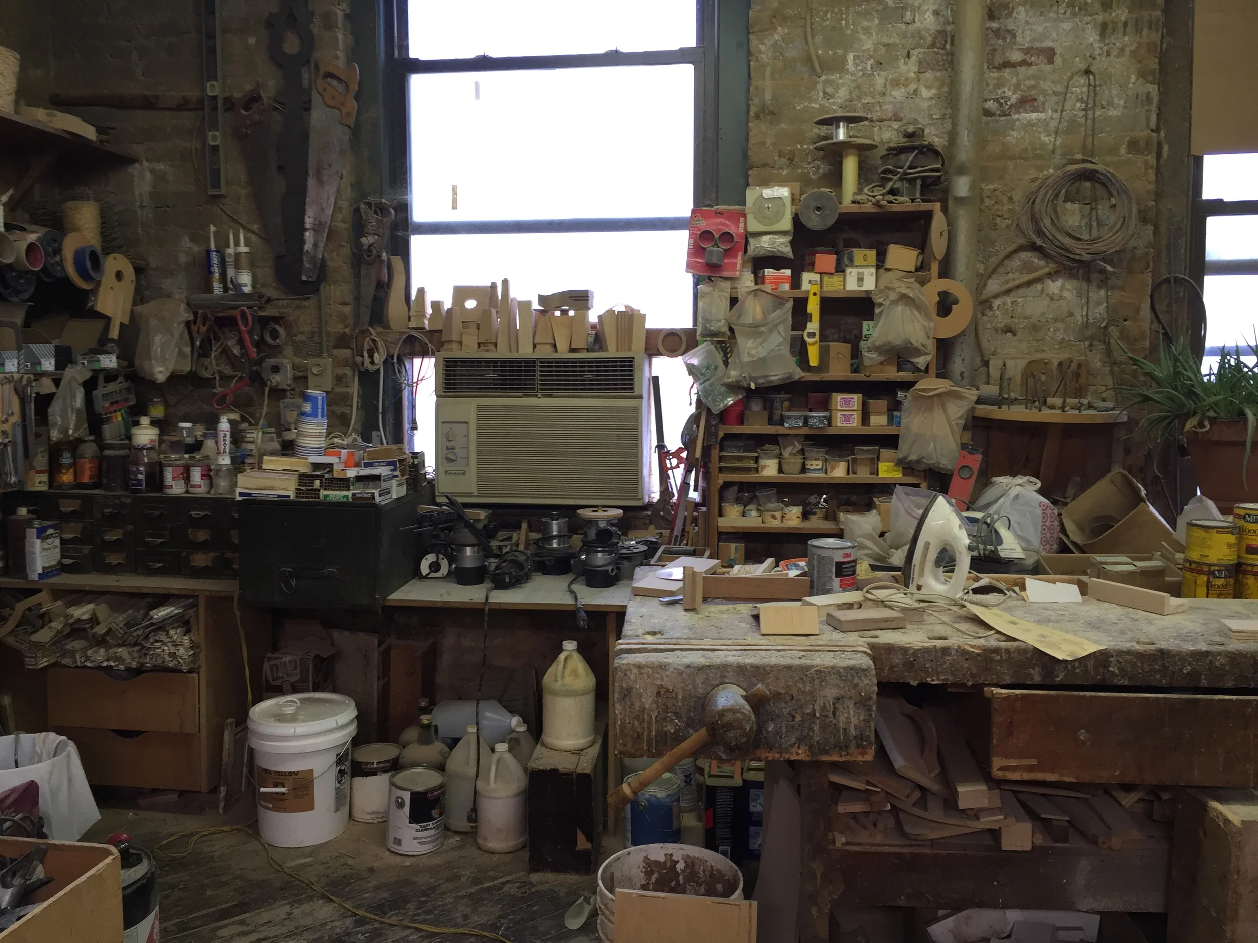 This area of his shop shows a well worn workbench, and evidence of year upon year of collecting tools, hardware and the paraphernalia required to make each piece of his handmade furniture. 