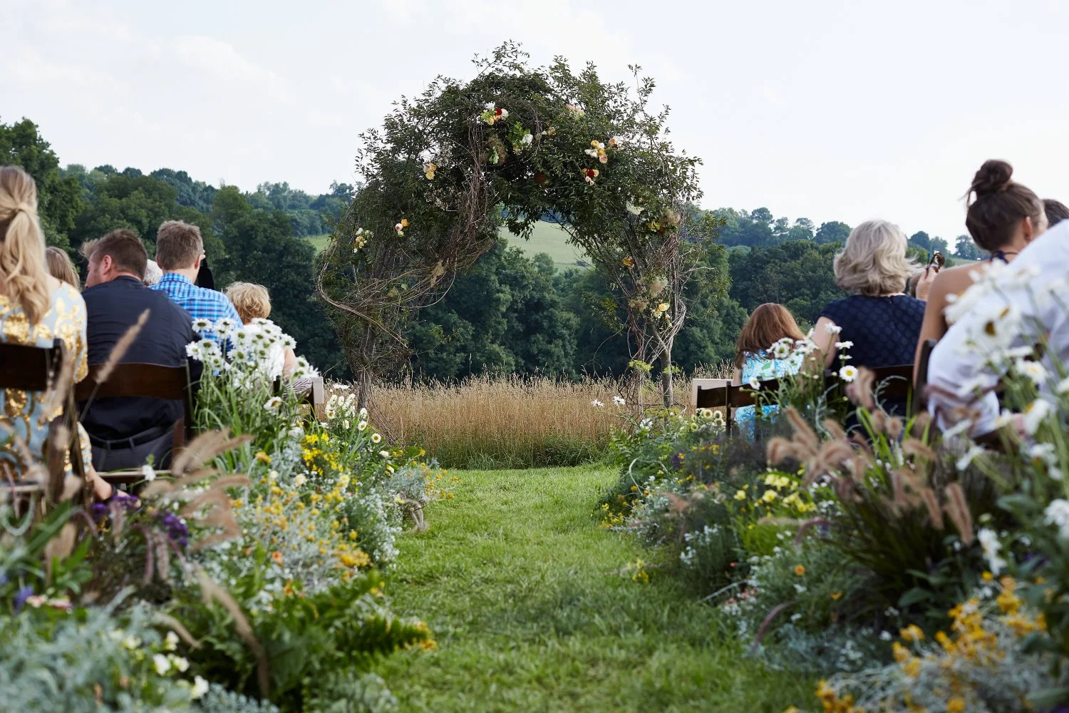 I wrapped the front arbor with giant grapevine and dotted flowers here and there. As you can see, we also lined the aisle with wildflowers, grasses and herbs.