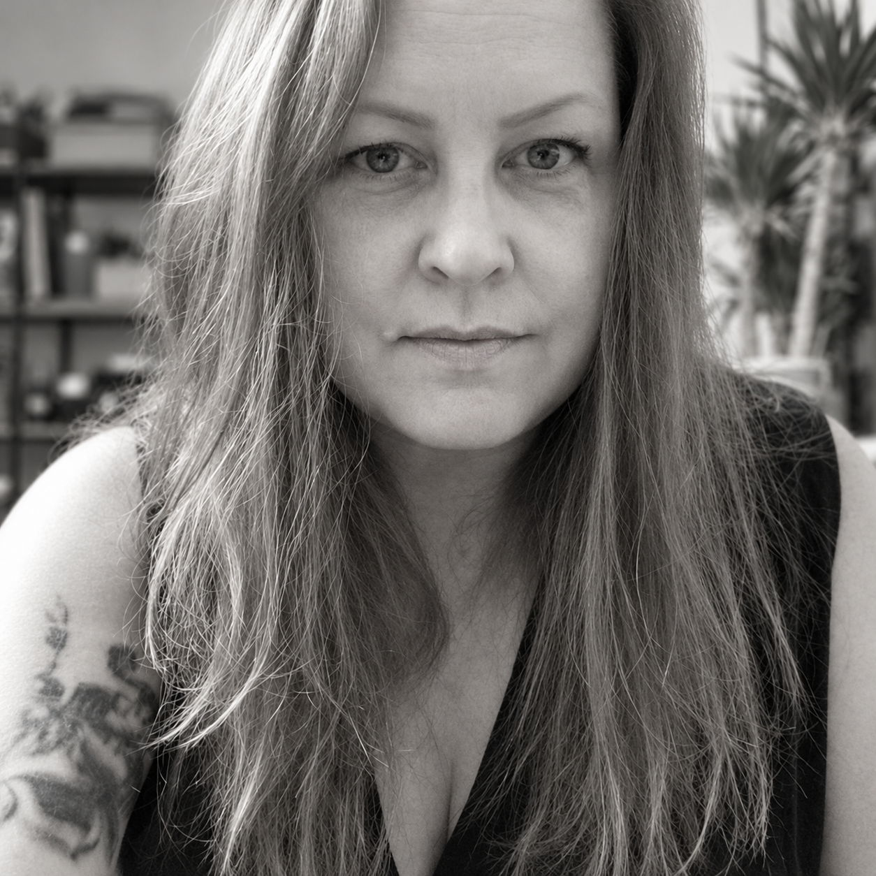 Black-and-white portrait of Deb Linehan, with plants in the background.