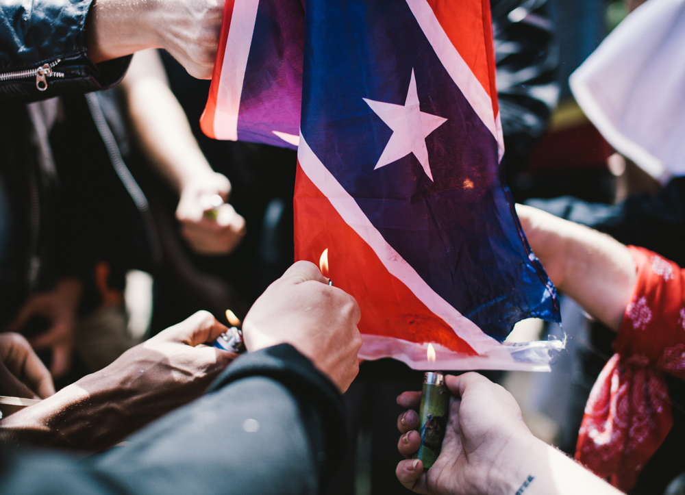 Counter-protesters attempt to burn a Confederate flag in Emancipation Park. (Seth Herald / The Atlantic)