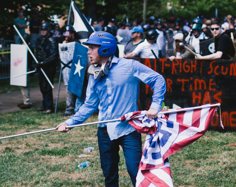 A white nationalist holds a modified American flag in Emancipation Park. White nationalist groups were met by counter-protesters and clashes broke out throughout the day. (Seth Herald / The Atlantic)