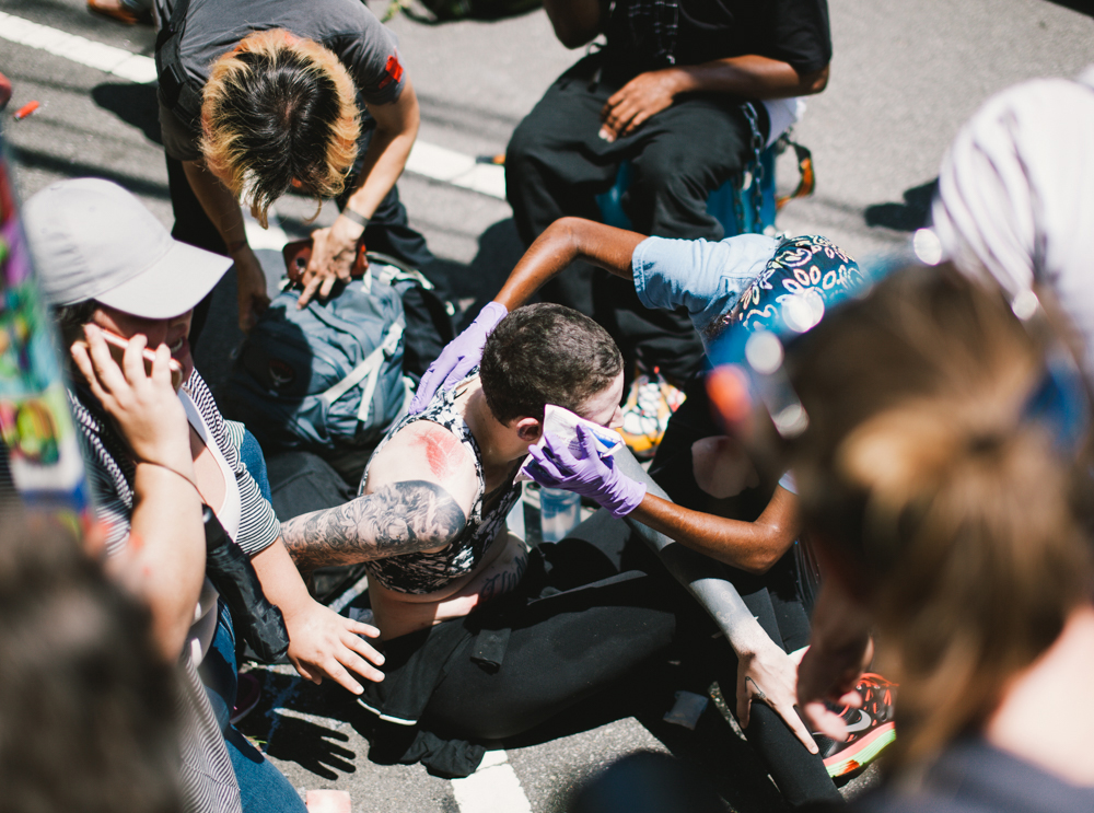 Bystanders assist a woman after she was struck by a car that drove into a crowd of counter-protesters in Charlottesville. (Seth Herald / The Atlantic)