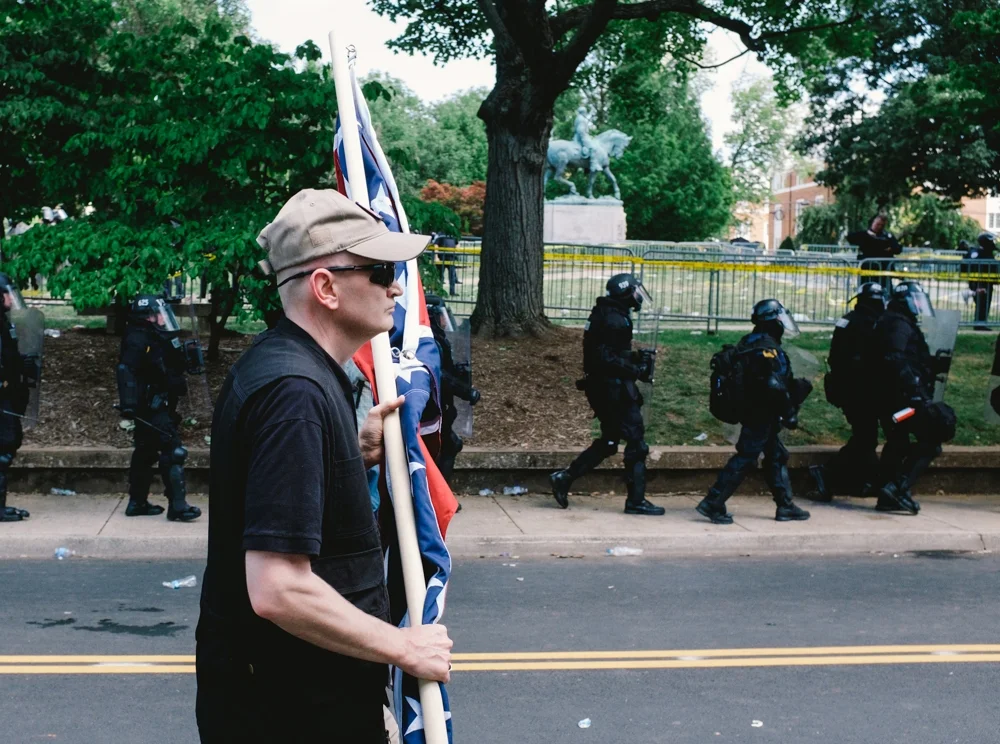 A white nationalist is seen leaving Emancipation Park in Charlottesville, Virginia, where violent clashes took place between counter-protesters and white-nationalist groups. Hundreds of white nationalists gathered at the park for a "Unite the Right" rally to protest the removal of the statue of Robert E. Lee, which is seen in the background. (Seth Herald / The Atlantic)