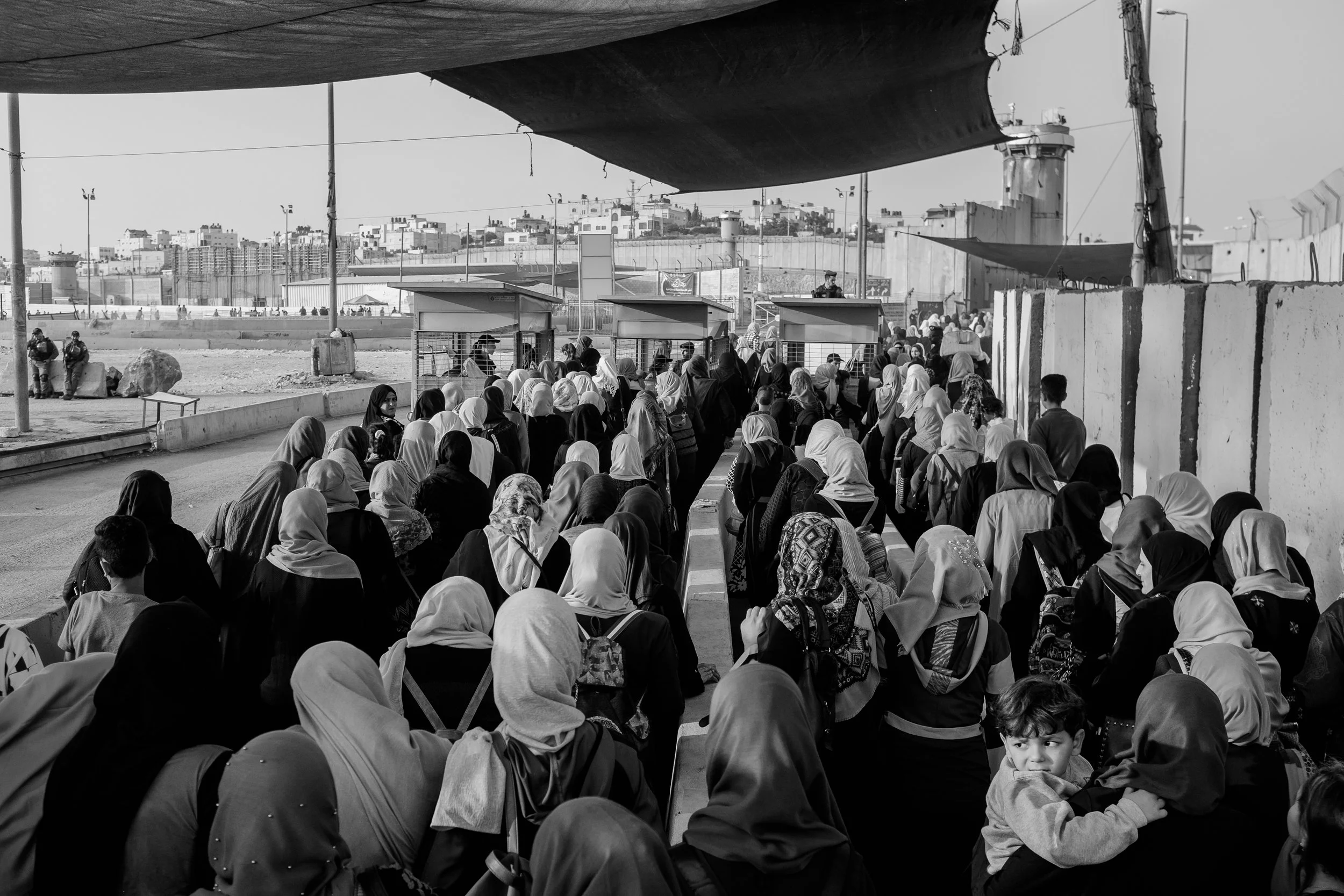 Palestinian women, on their way to pray at Al-Aqsa Mosque, one of the holiest sites in the Muslim world, wait to pass through one of the Qalandiya checkpoints during Ramadan. The West Bank village of Qalandiya is home to one of the busiest military checkpoints in all of the Occupied Palestinian Territories. which an estimated 26,000 Palestinians are forced to pass through every day. (Seth Herald/Redux Pictures)