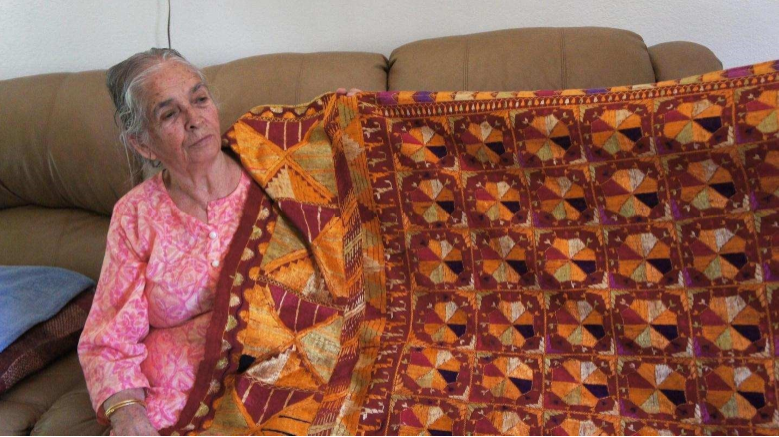 Amrik Kaur, age 83 with a phulkari that her mother hand-embroidered and passed down to her. Photo by Conner Singh Vanderbeek.