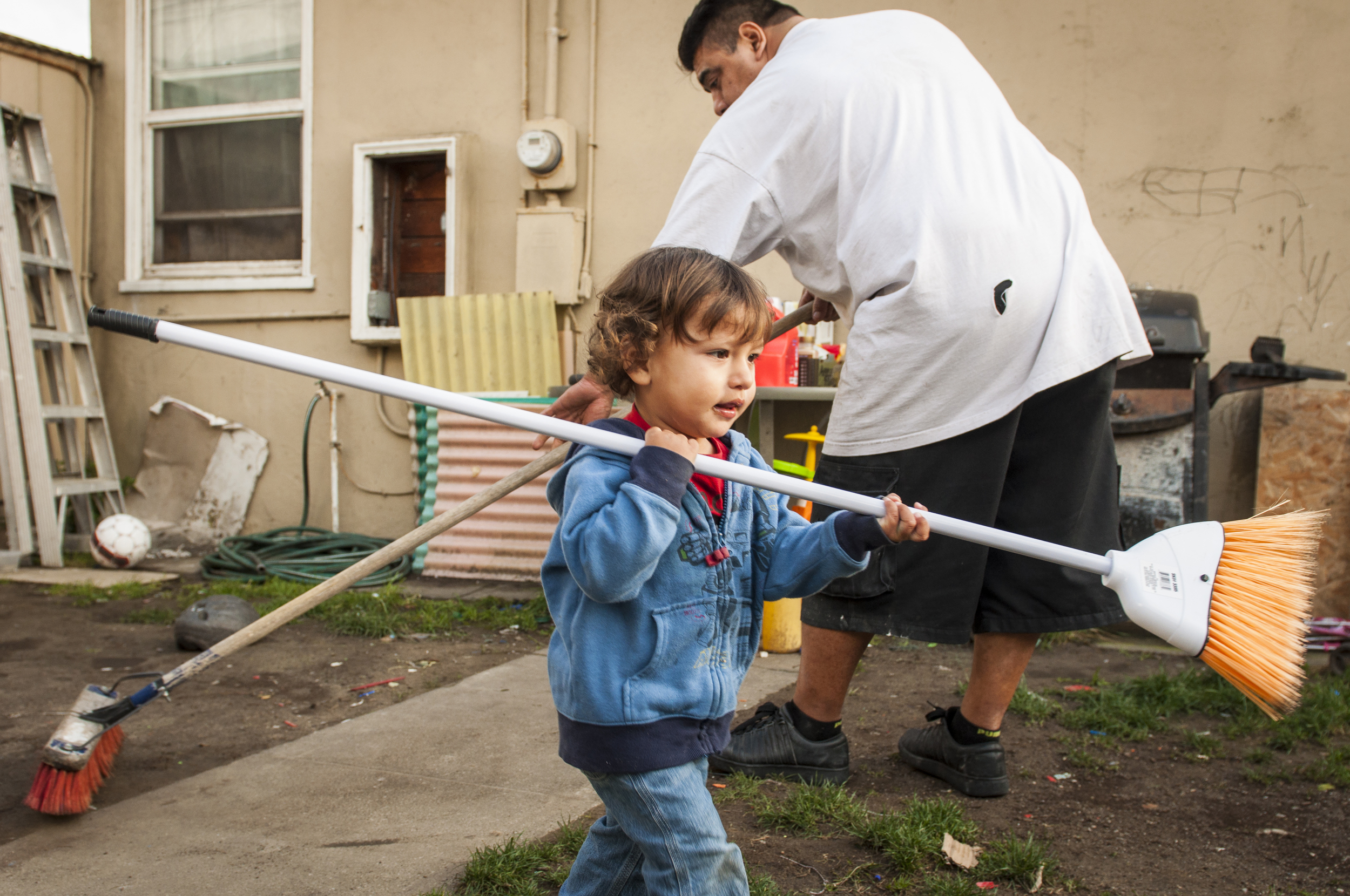  Dominic and his father Felipe clean the back yard. 