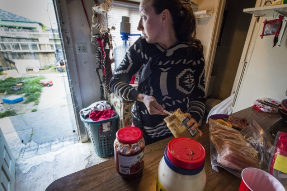 Amanda, 27, prepares the lunch boxes for her 3 children. There is no proper kitchen in her home, only a hotplate. The refrigerator is located in a separate garage. &