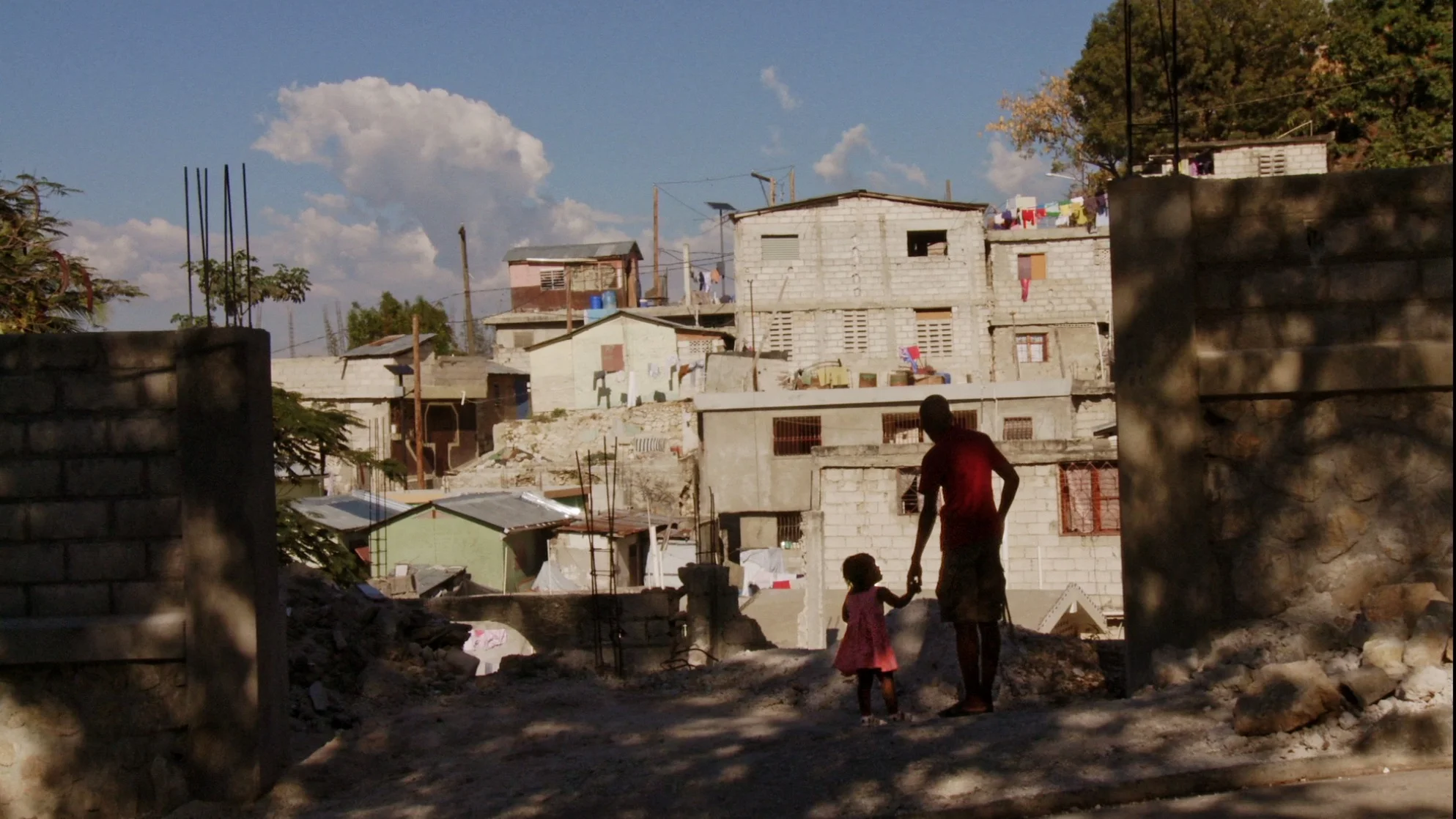 MV and baby sister before Haiti buildings.jpg