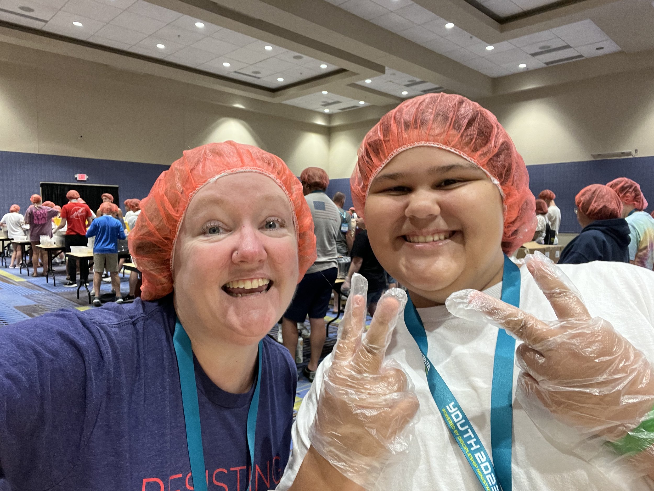  Bonnie Bevers and Madi Ramirez helping pack food with Rise Against Hunger at Youth 2023 service project 