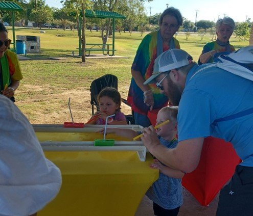 Young children and their families doing the boat race at the Recreation Station.