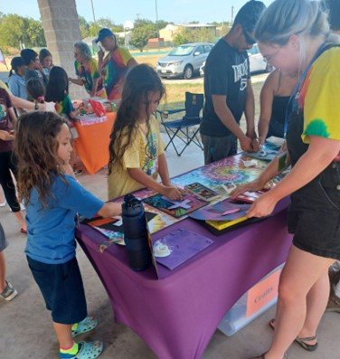 Children making a tie dye cross reveal craft at the Craft Station.