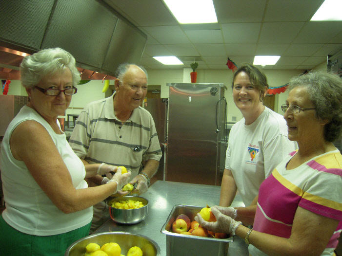Volunteers peel peaches in preparation of the festival