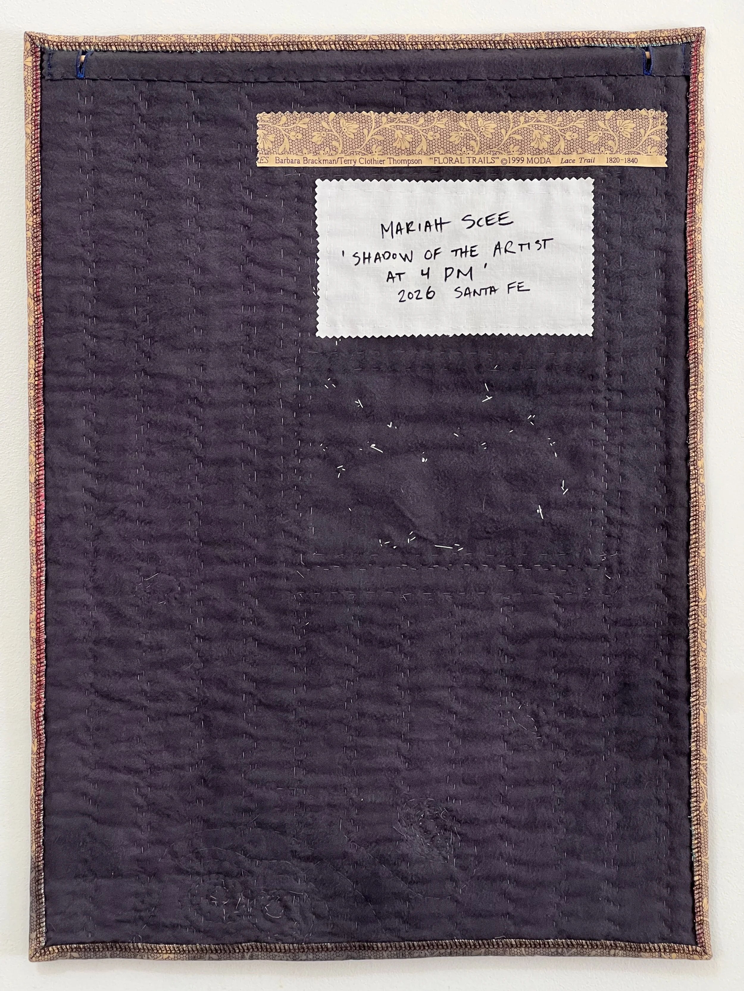 Reverse side, with a piece of the selvadge of the quilting cotton sewn in. Writing on the selvadge dates the fabric to 1999, and that it is a reproduction of an 1800's textile