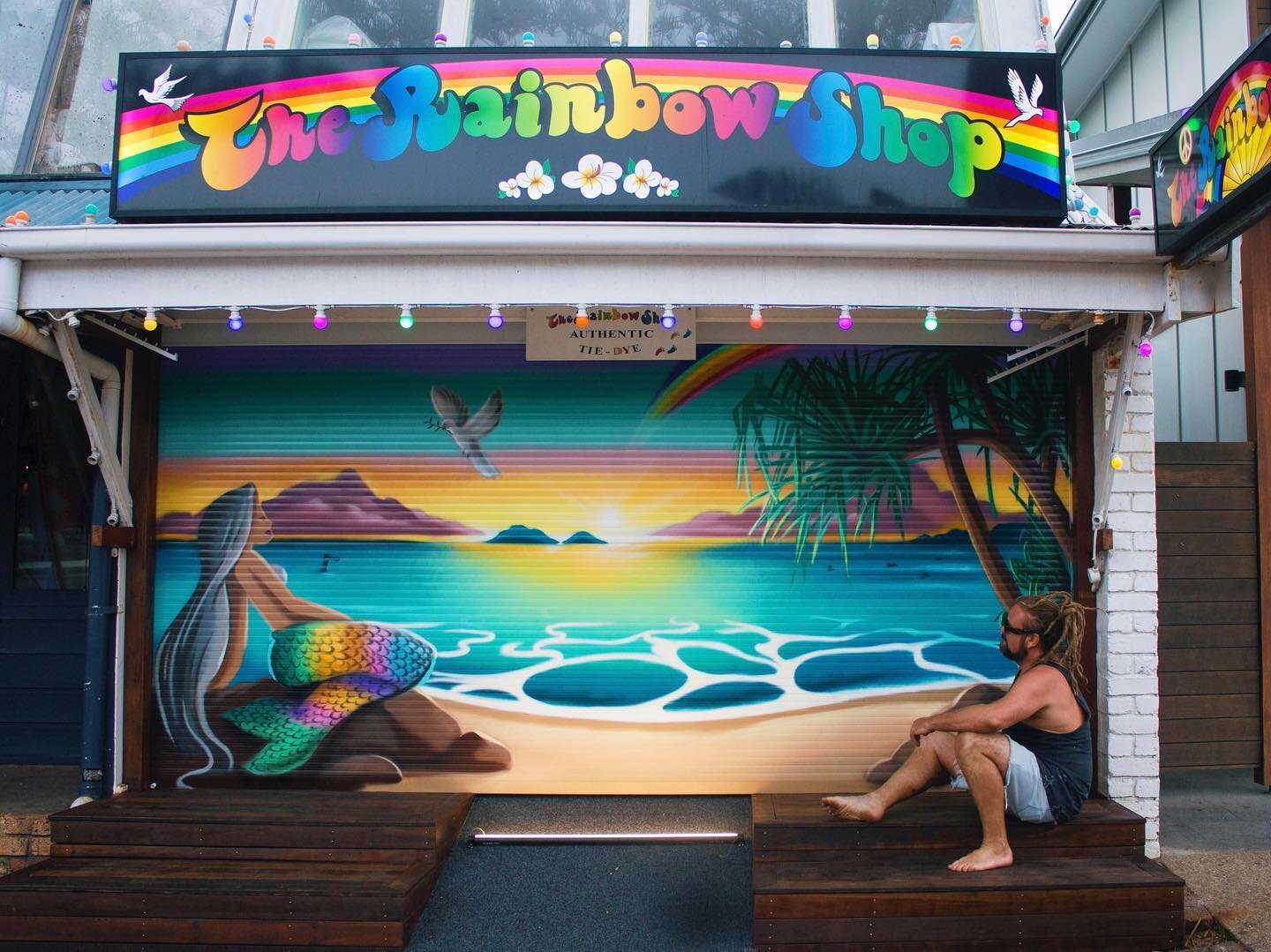 Roller door mural painted for the rainbow shop in Byron Bay. 💙✌️🌈✨

The mural features a rainbow mermaid gazing out at juilian rocks. A popular dive spot just of the coast. 🌊 

It also includes a white dove which resembles peace and harmony. A rem