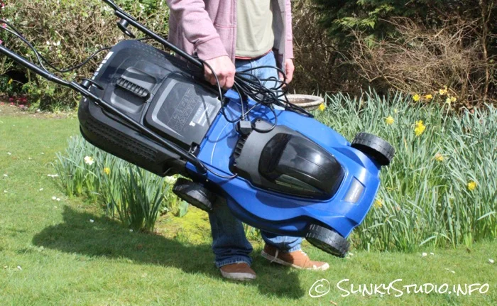Einhell BG-EM 1437 Electric Lawnmower Being Carried in front of Flower Meddow.jpg