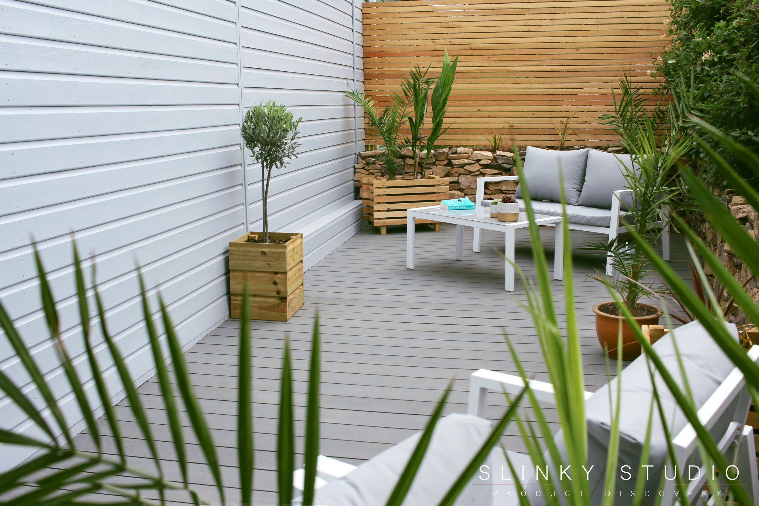 Havwoods Trekker Composite Designer Decking Vulcan Grey Lifestyle Looking Through Phoenix Palm Tree.jpg