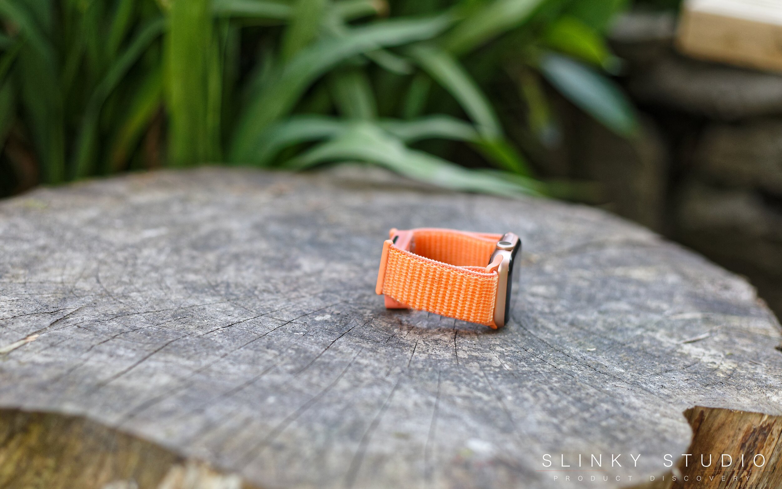 Aura Strap for Apple Watch Peach Red Lying on Wooden Toadstole Table.jpg