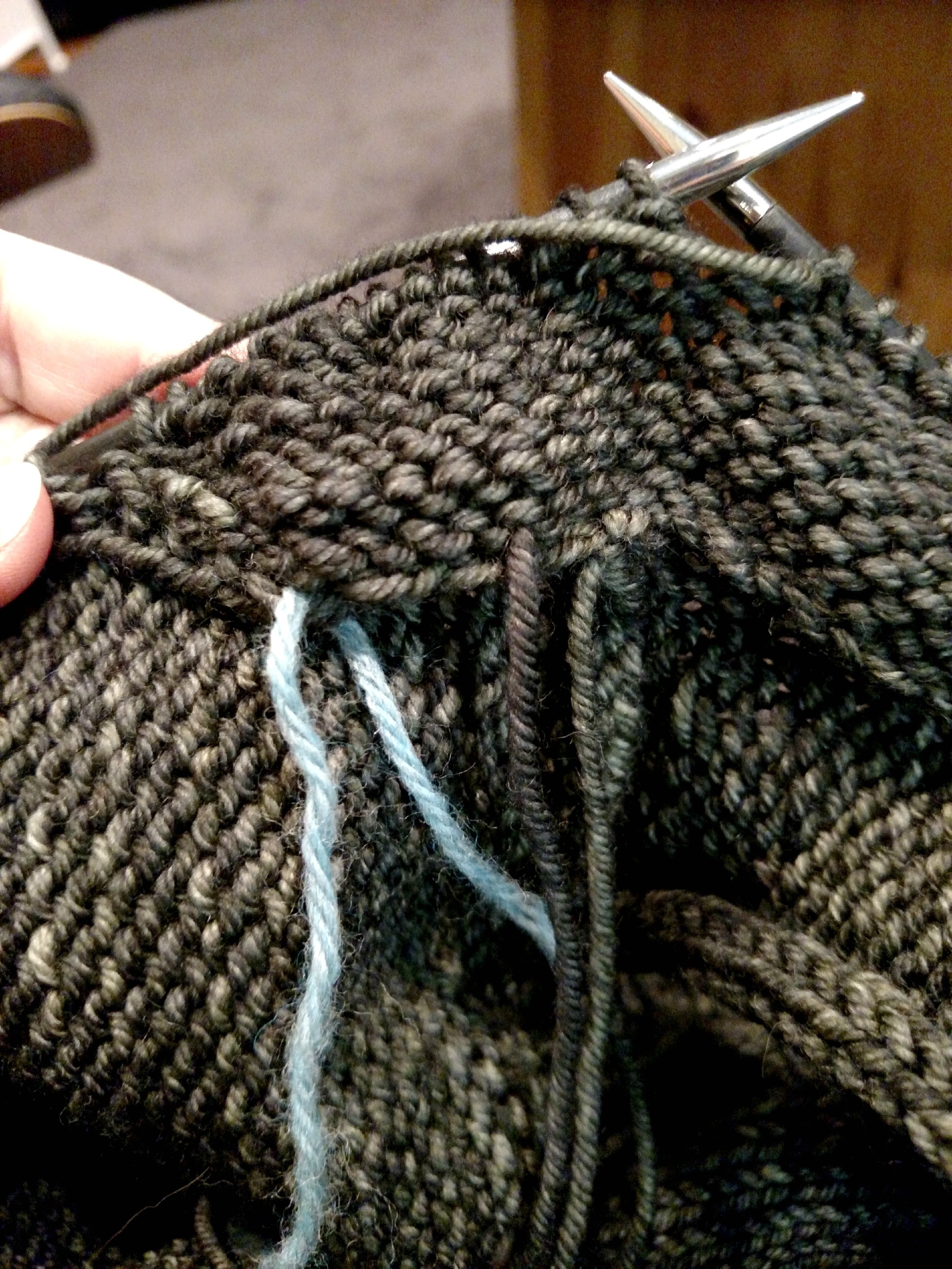 inside the sleeve cap in progress, working back across the inside short rows. That length of blue yarn is the marker I used to note where the short rows began on the picked up stitches