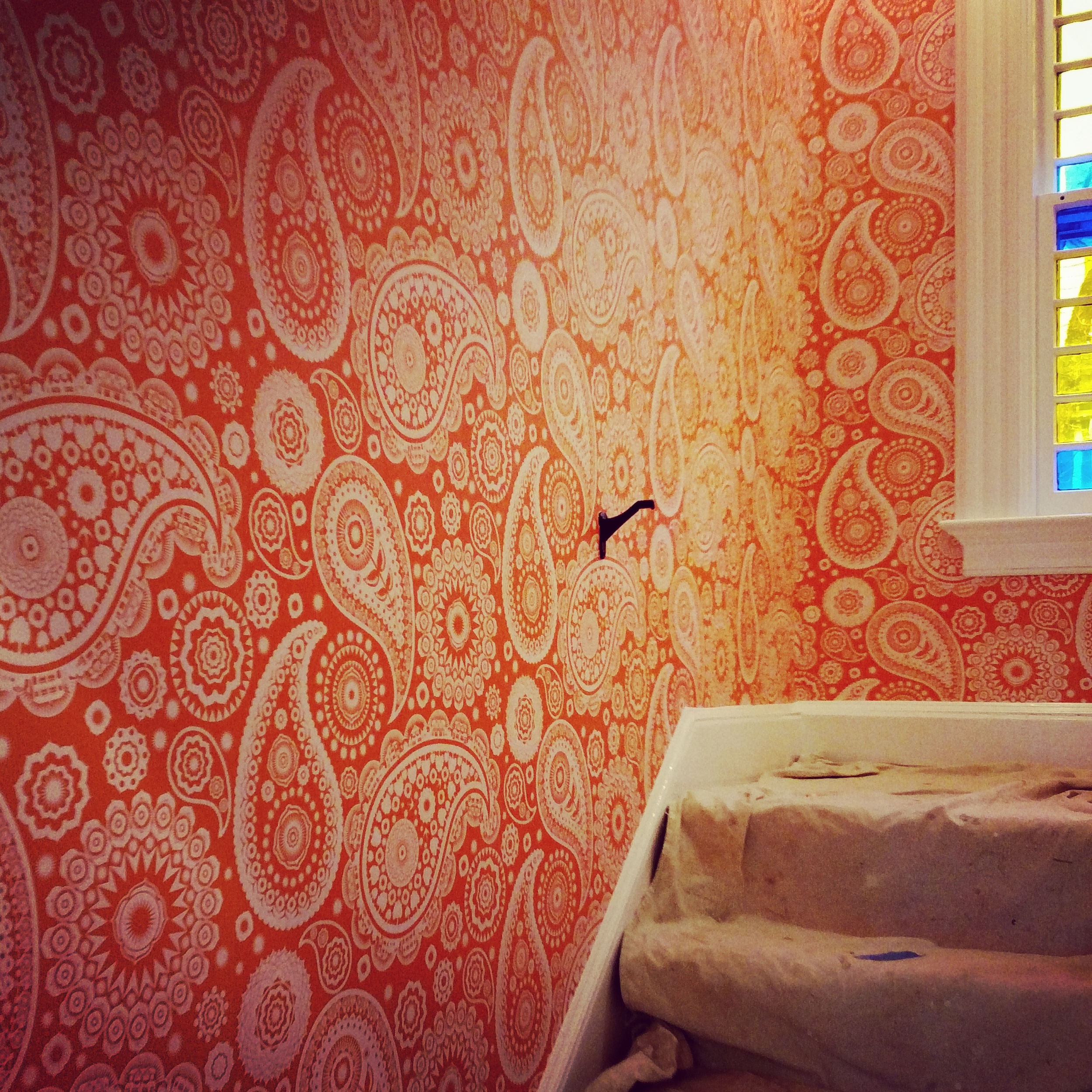 Mini Moderns Paisley Crescent wallpaper in Tangerine Dream. The paisleys have lil houses and bikes in them!