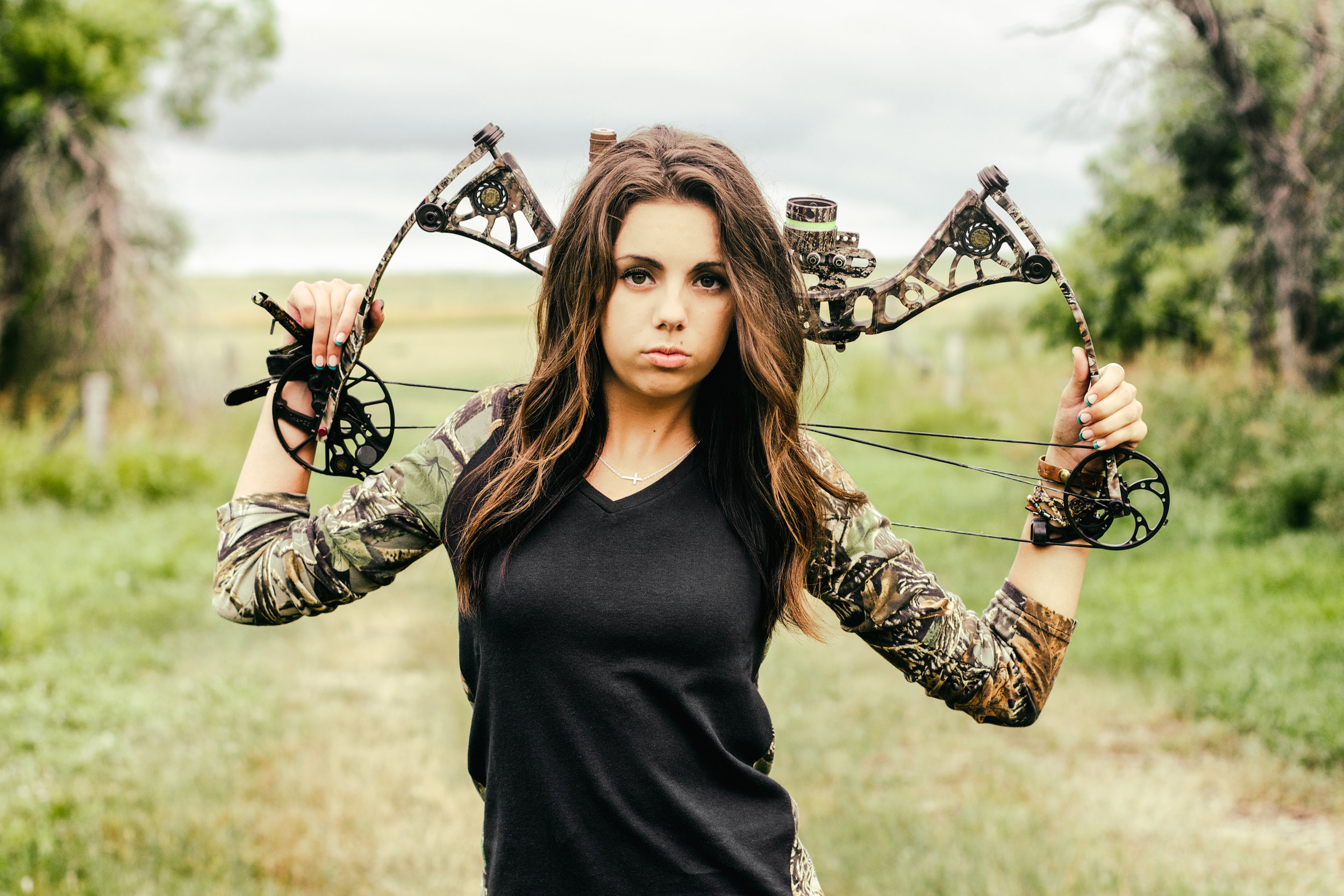 girl holding compound bow in a field (Copy)